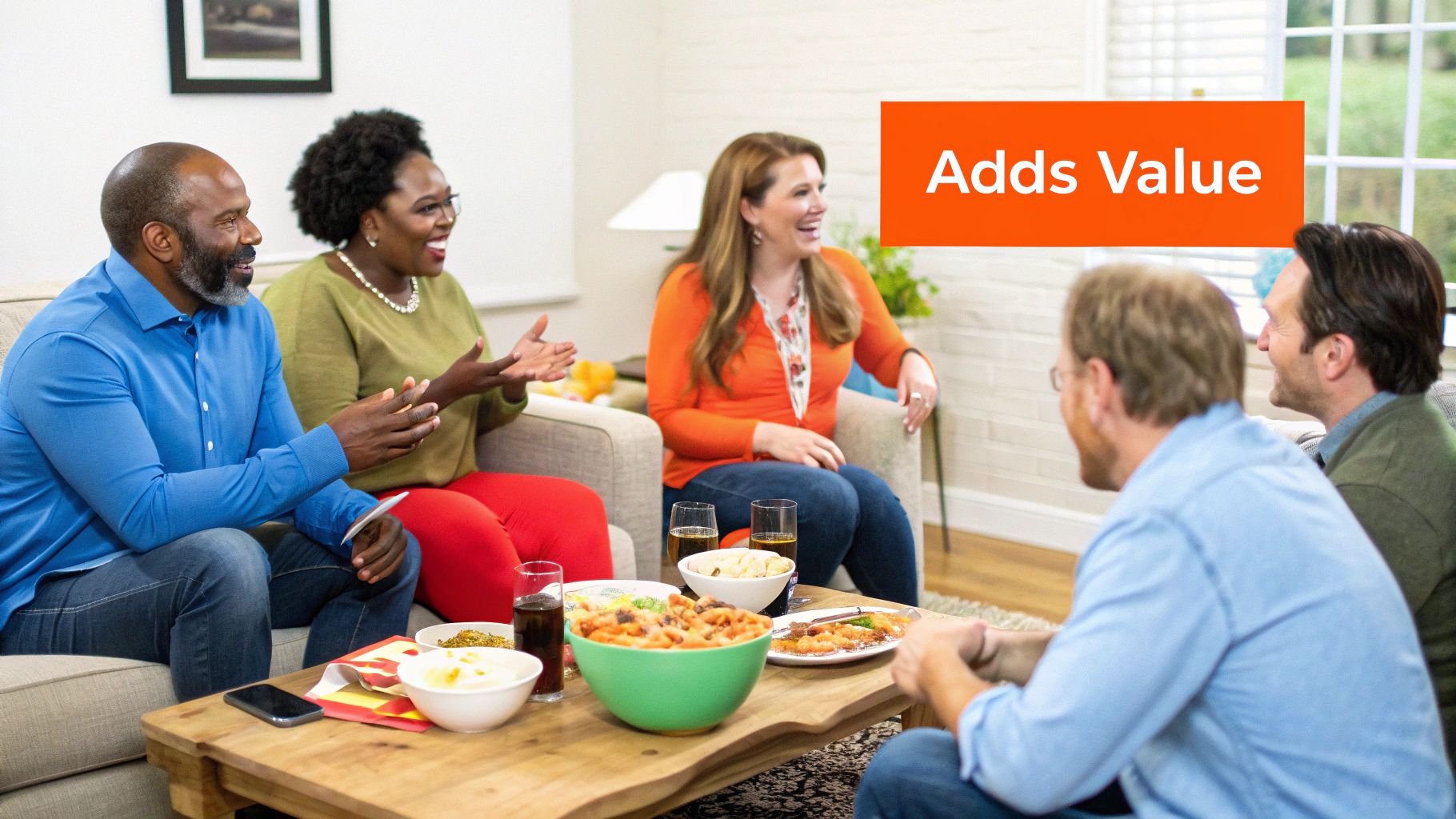 A diverse group of friends smiling and talking in a living room with food and drinks.