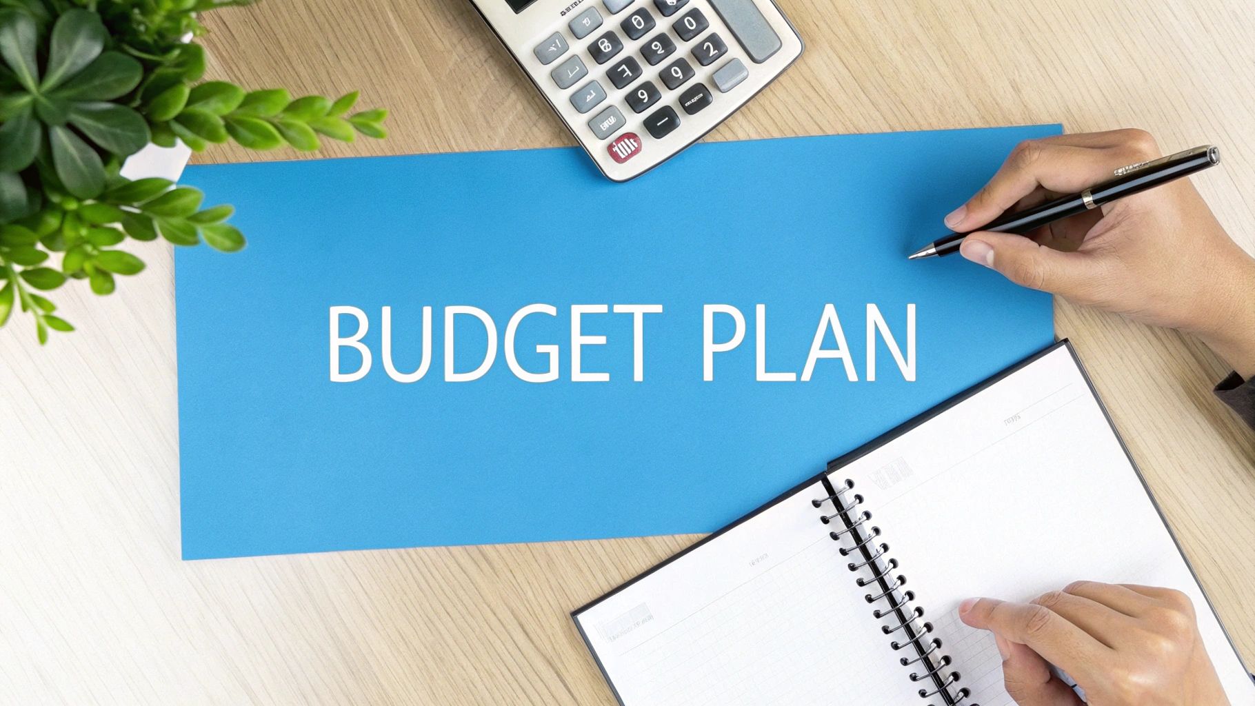 Individual writing a budget plan using a calculator as a helpful tool 