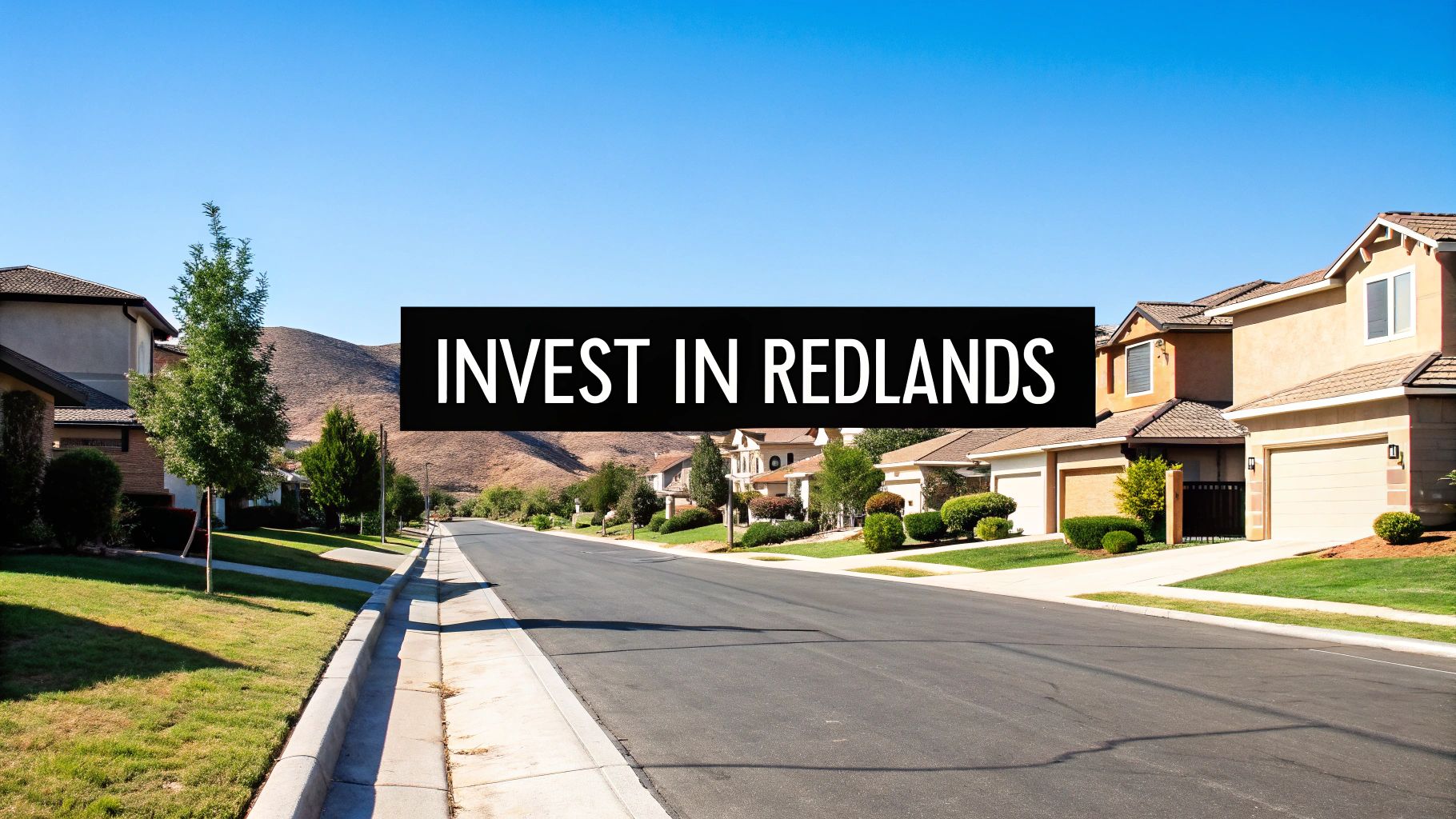 A clear day in Redlands, California, showing a residential street with houses, lawns, and hills.