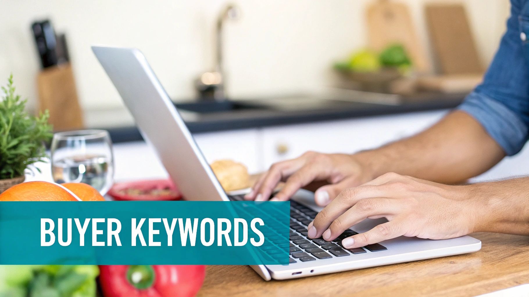 A person is typing on a laptop in a kitchen setting with 'BUYER KEYWORDS' text overlay.