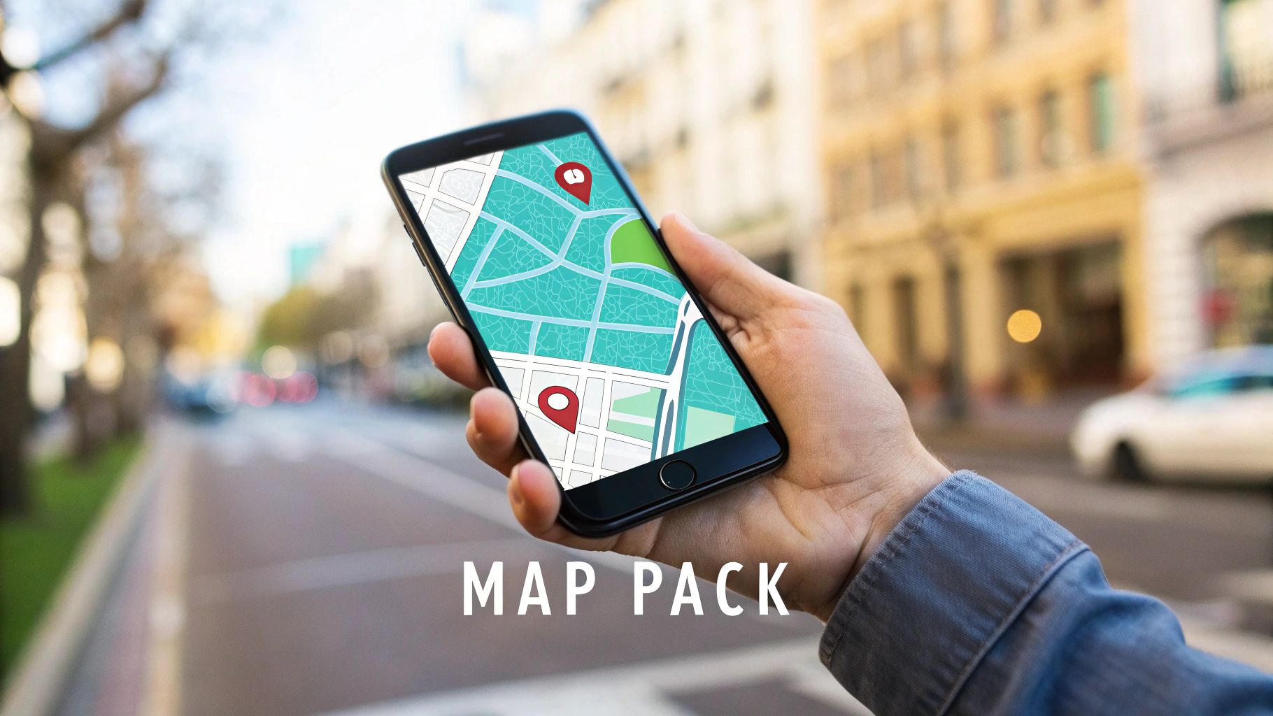 A hand holds a smartphone displaying a digital map with two red location pins in a city street setting.