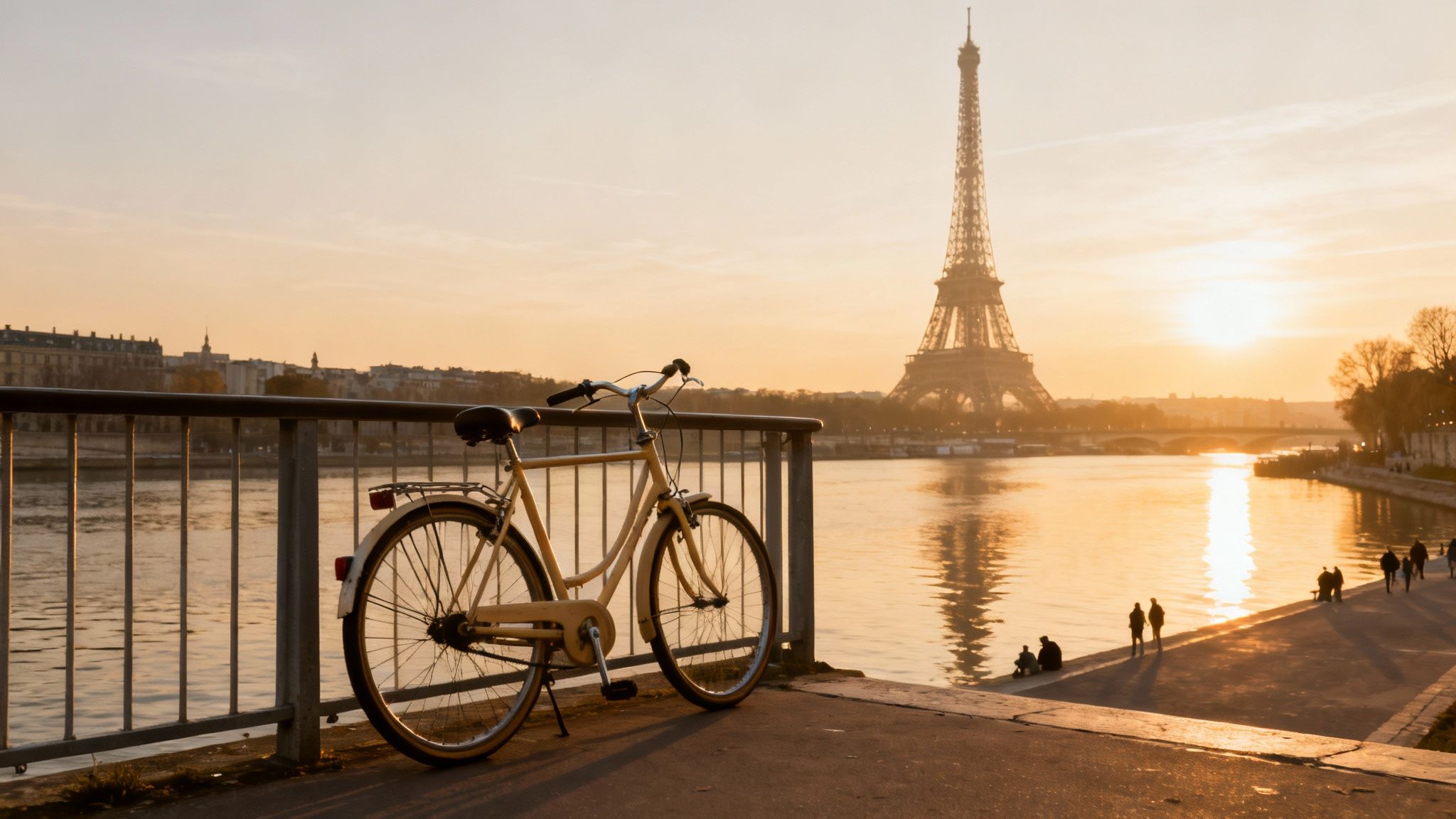A classic bicycle parked by the Seine River with the Eiffel Tower in the golden sunset.