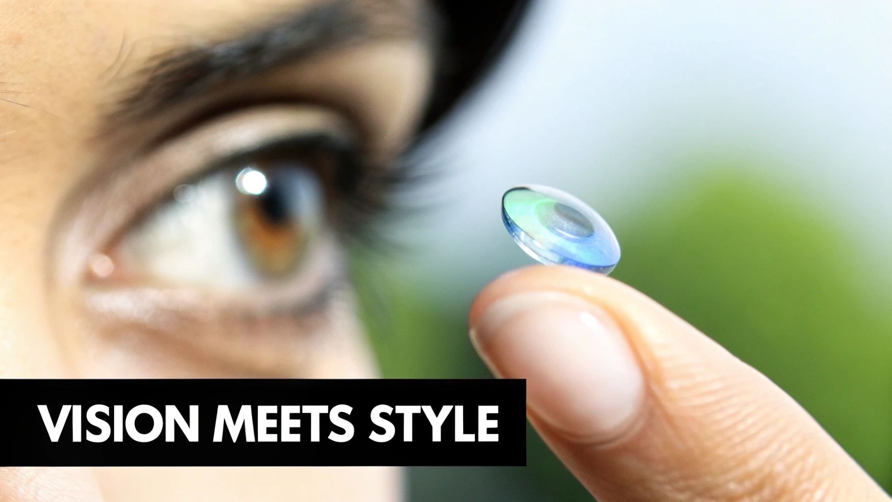 Close-up of an eye looking at a green and blue colored contact lens on a fingertip.