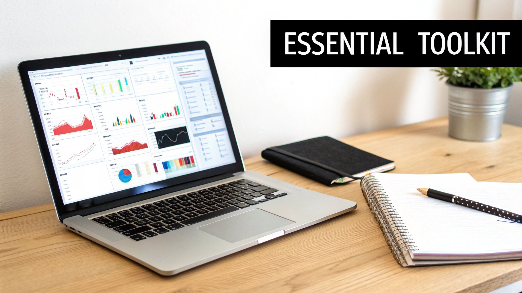A clean wooden desk with a laptop displaying data charts, notebooks, a pen, and a plant.