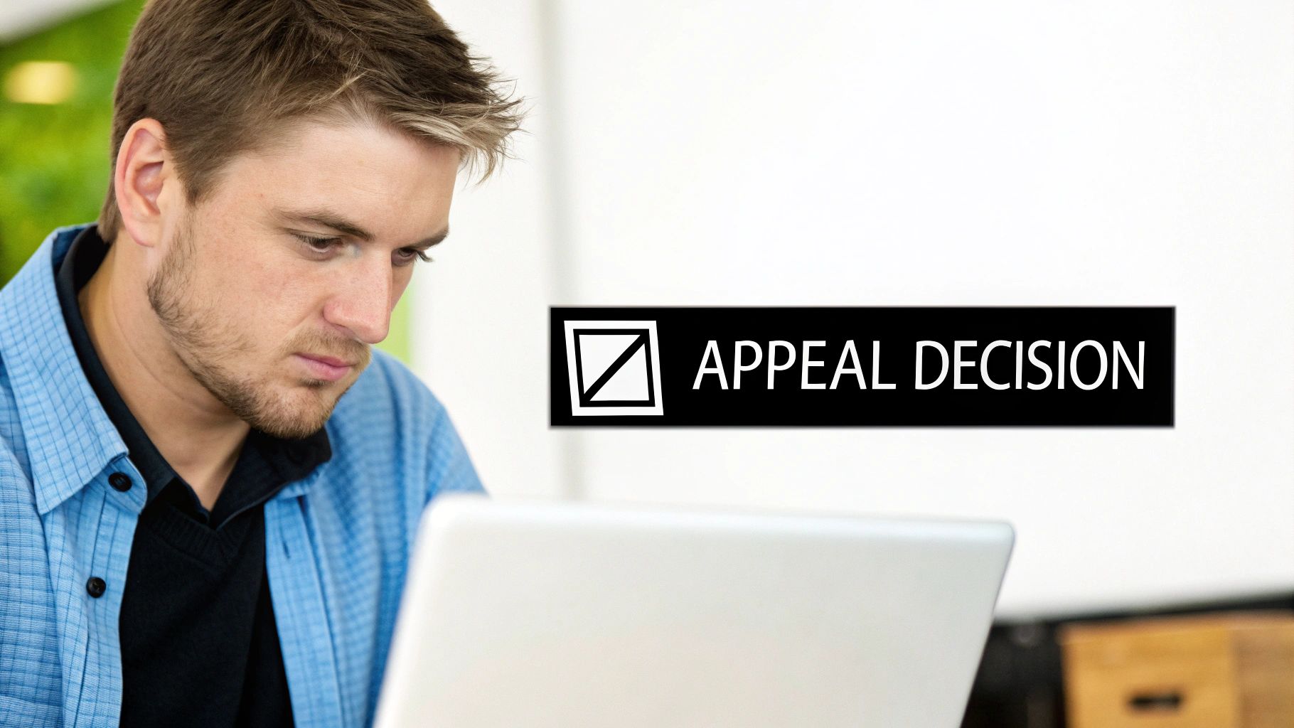 A focused man reviews an appeal decision on his laptop, with a checkbox graphic.
