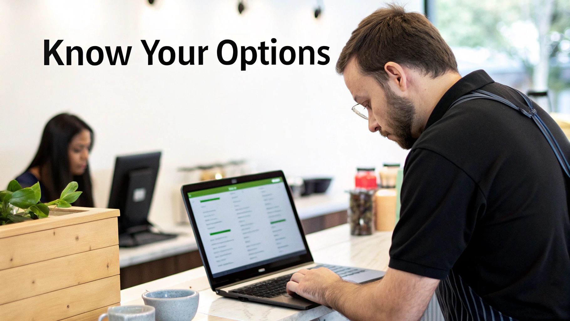 A man in a cafe, wearing an apron, looks at a laptop displaying menu options, with 'Know Your Options' text.