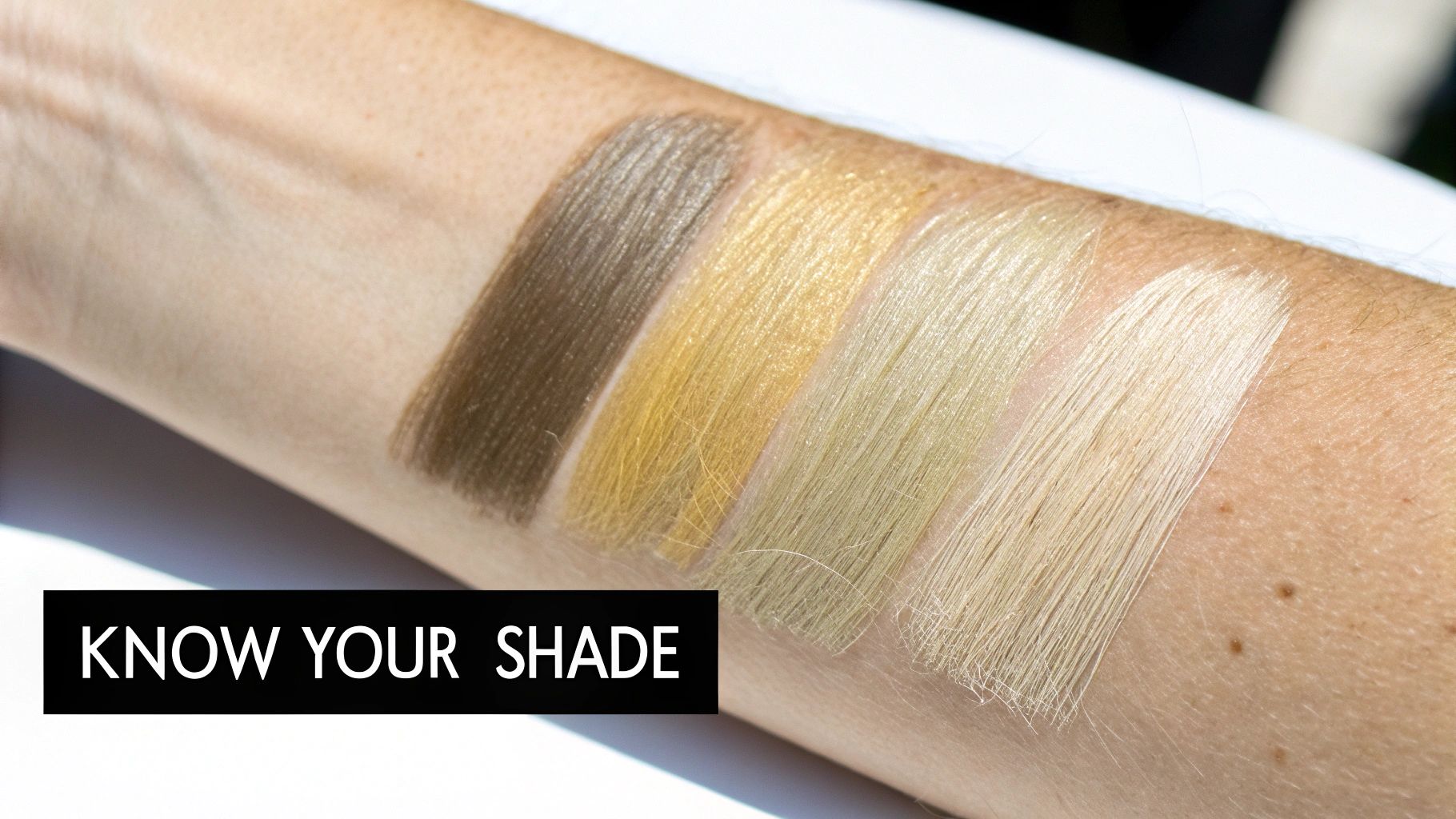 Four hair swatches, from dark brown to light blonde, displayed on a person's arm.