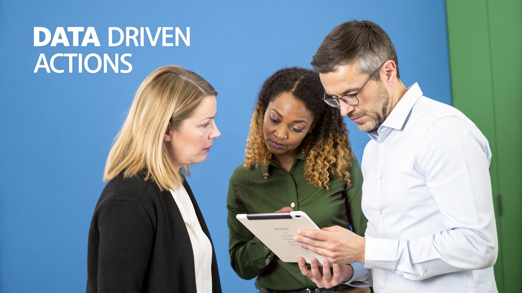 Three diverse professionals, two women and one man, collaborate while looking at a tablet, discussing data driven actions.