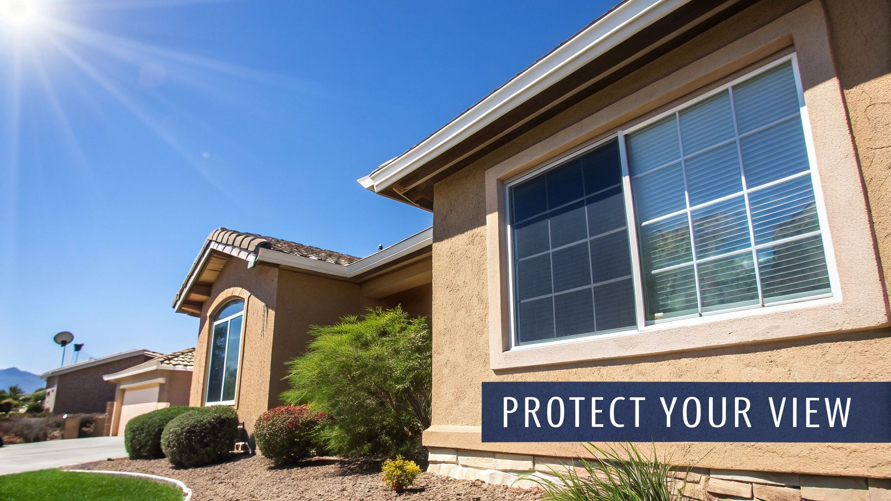 A stucco house exterior with multiple clean windows, one featuring blinds, under a sunny blue sky.
