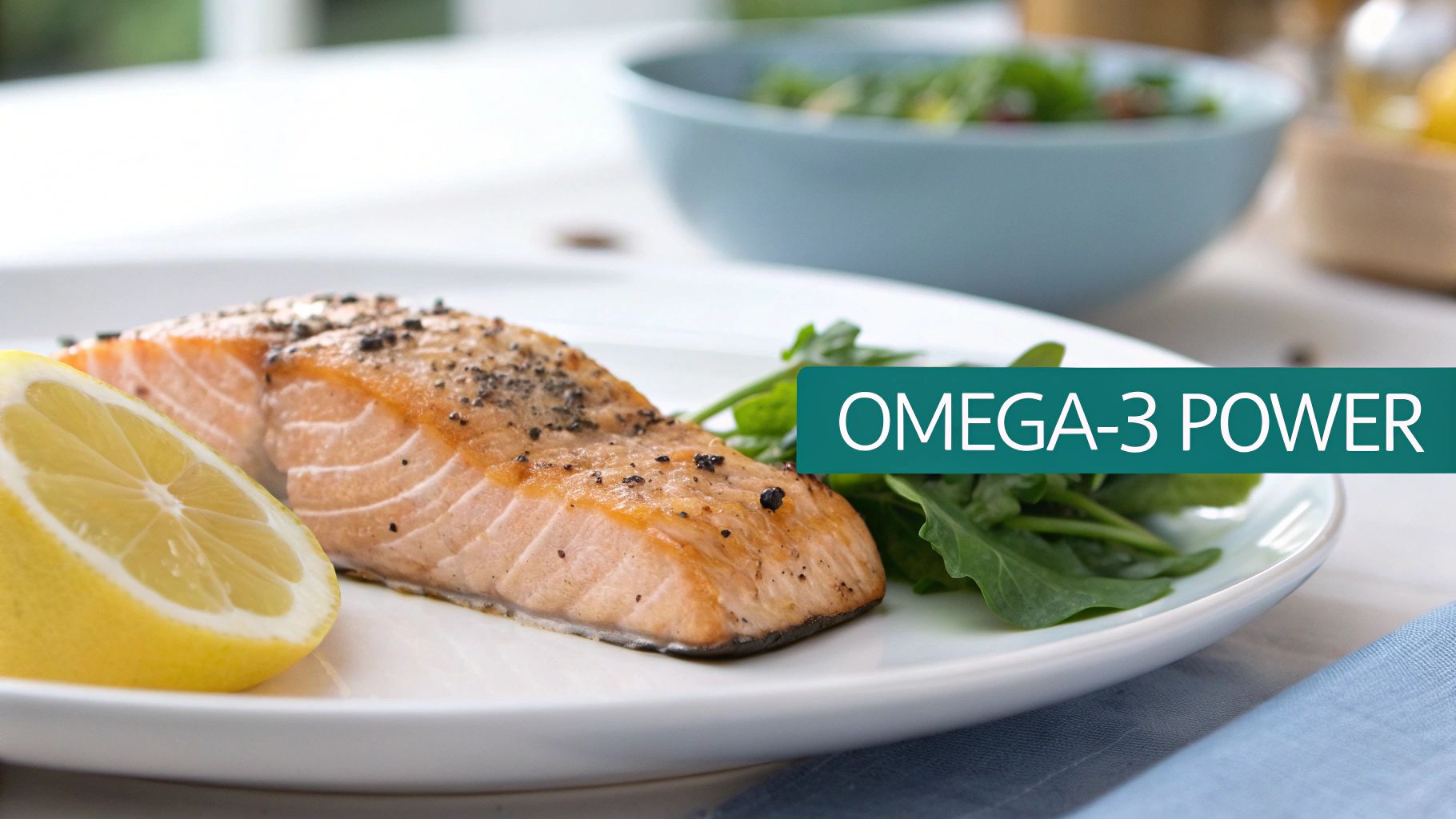 A healthy meal of seasoned salmon fillet, lemon wedge, and green salad on a white plate.