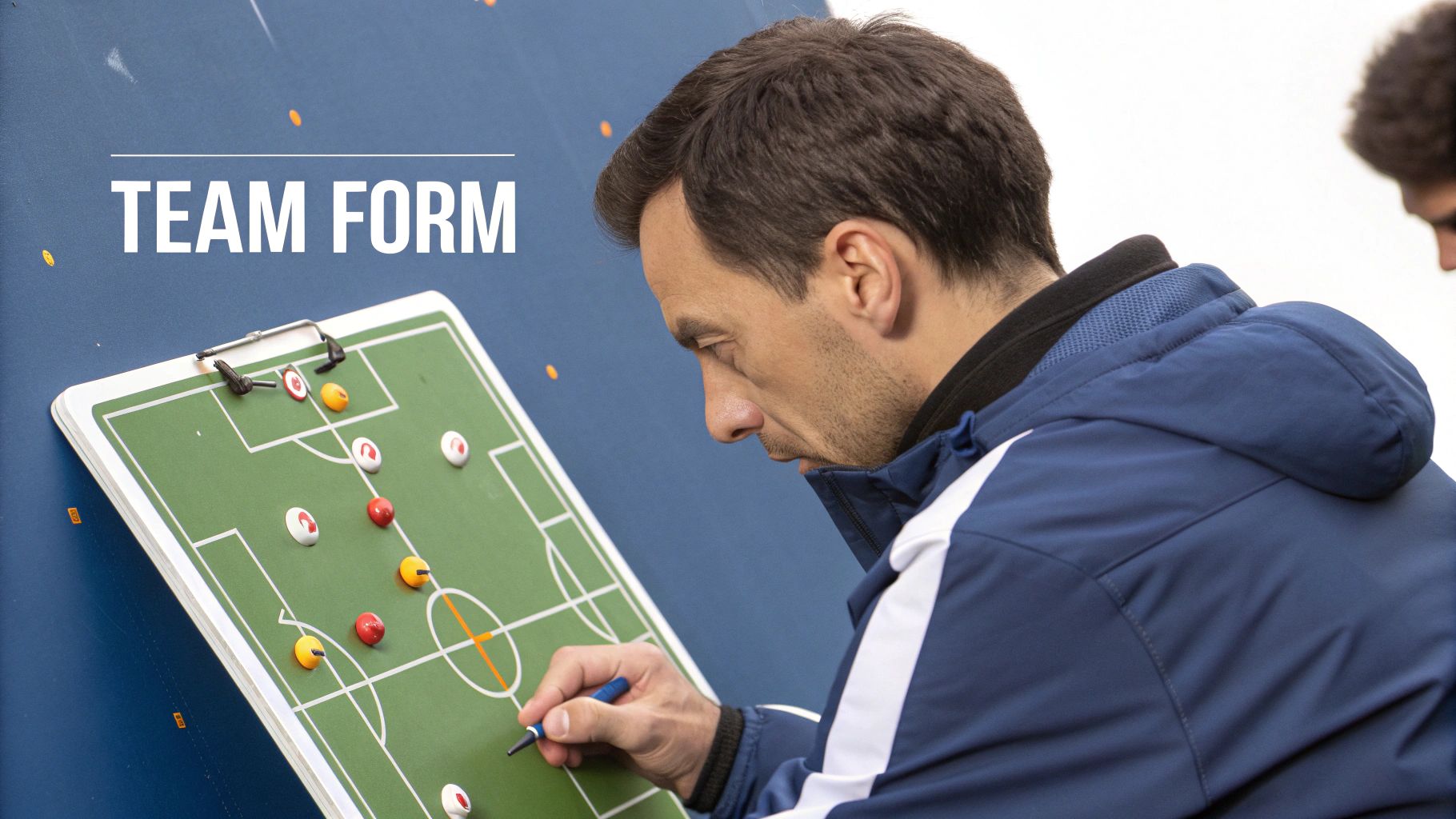 A manager giving tactical instructions to a football player on the sidelines during a match.