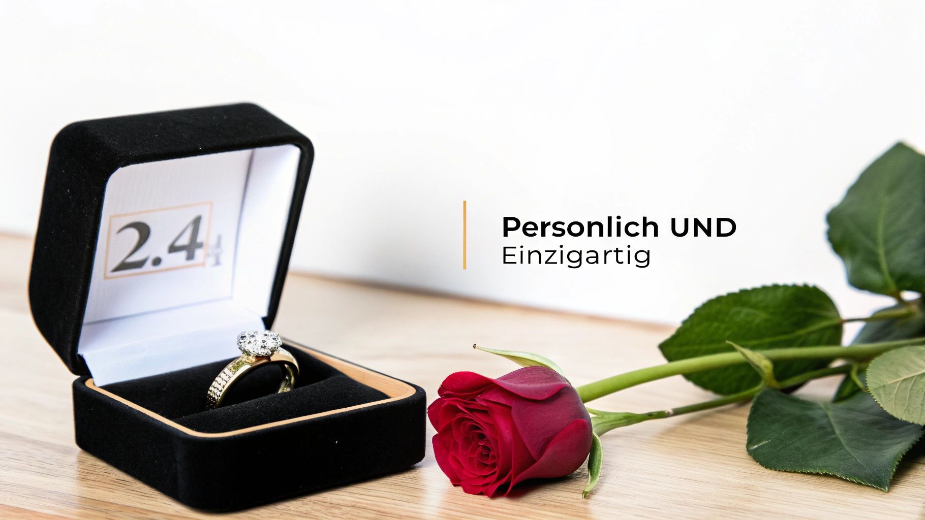 Un anillo de diamantes dorado en un joyero negro abierto, junto a él una rosa roja sobre una mesa de madera.