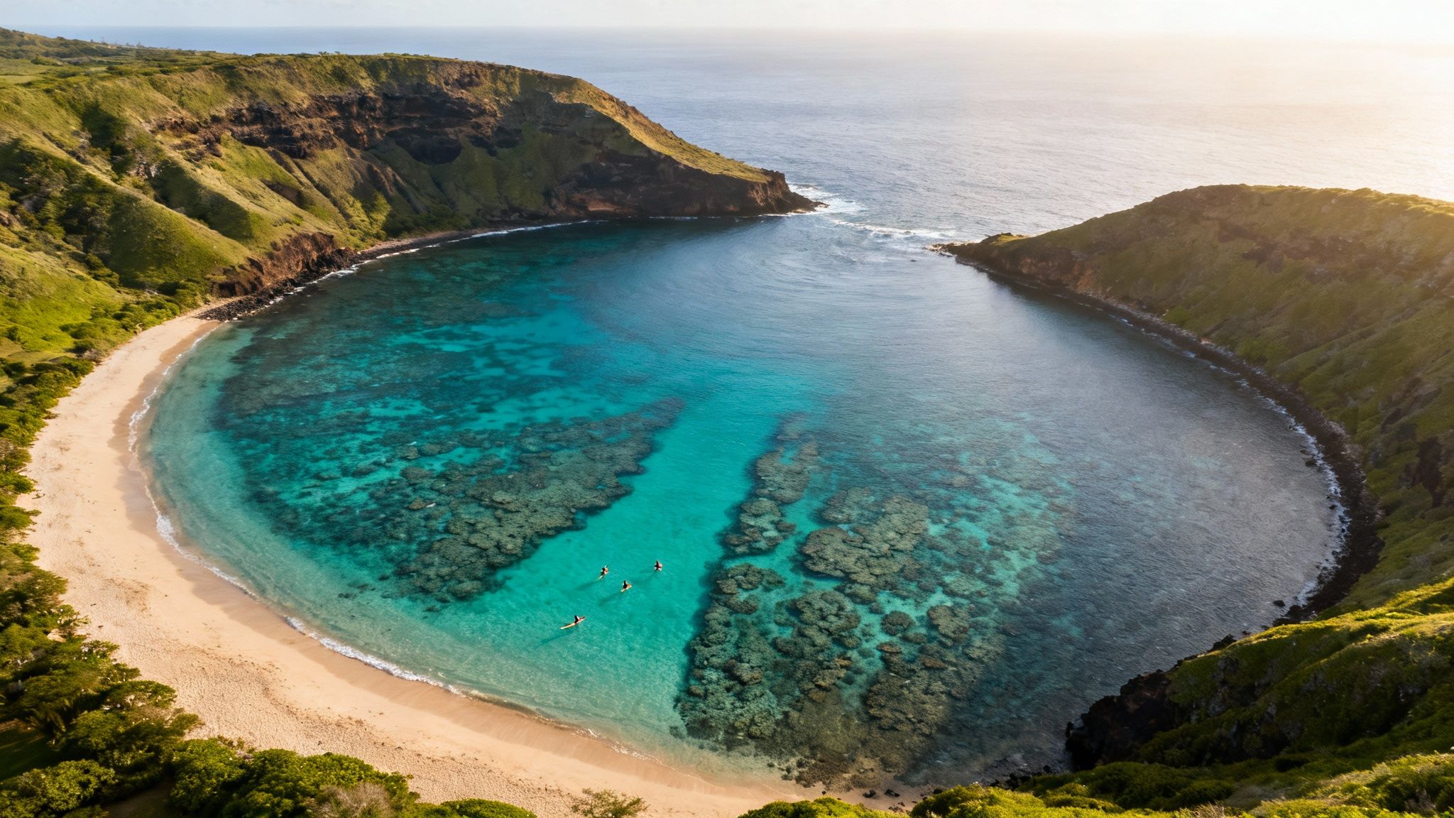 Aerial view of Hanauma Bay, Oahu, with vibrant turquoise water, coral reefs, and sandy beach.