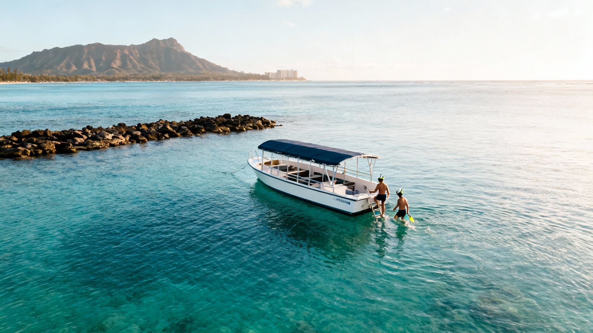 Two men in snorkeling gear near a boat in clear blue Hawaiian waters with Diamond Head in the background.