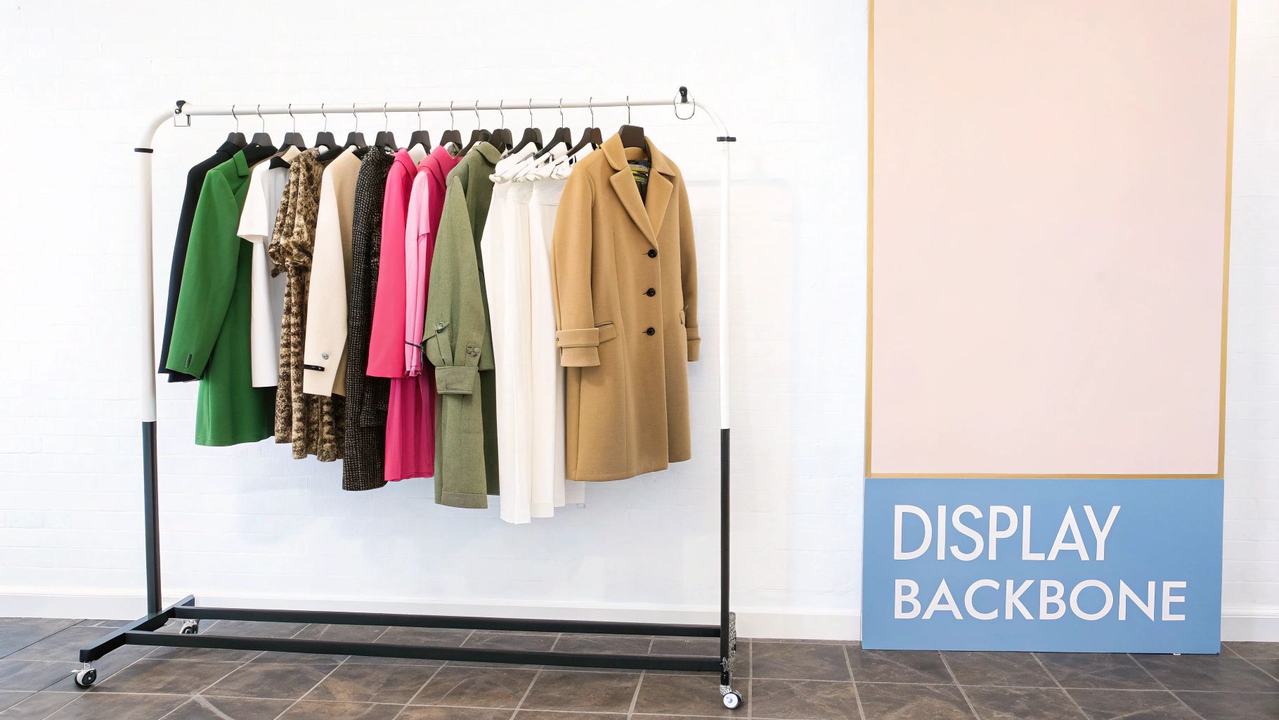 A mobile clothing rack displays various colorful coats and blouses next to a 'DISPLAY BACKBONE' panel.