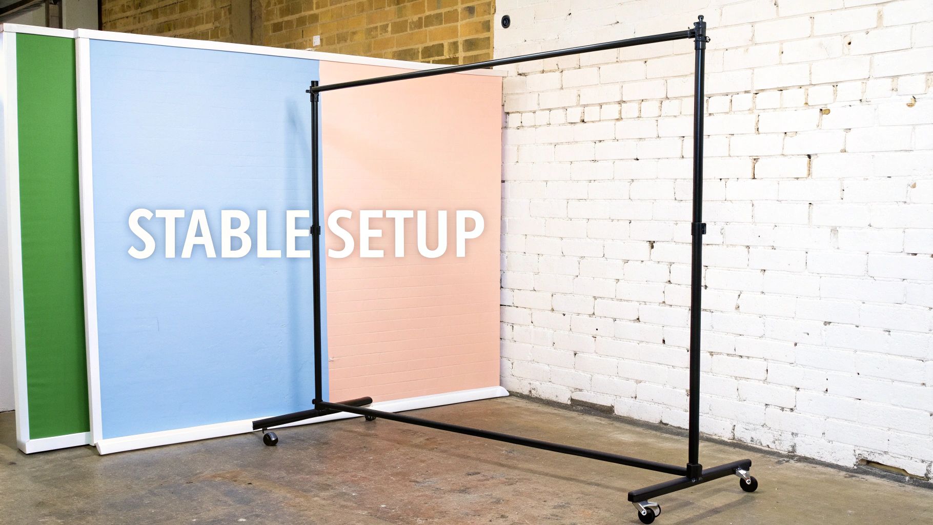 A black metal clothes rail on wheels stands in front of green, blue, and pink panels with 'STABLE SETUP' text.