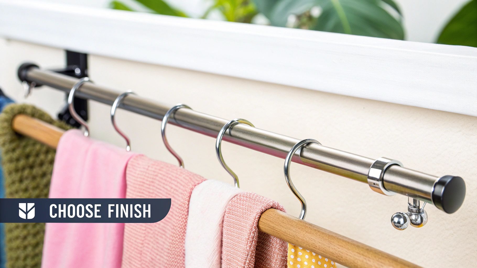 A close-up of a brushed metal extendable hanging wardrobe rail with S-hooks holding colorful scarves.