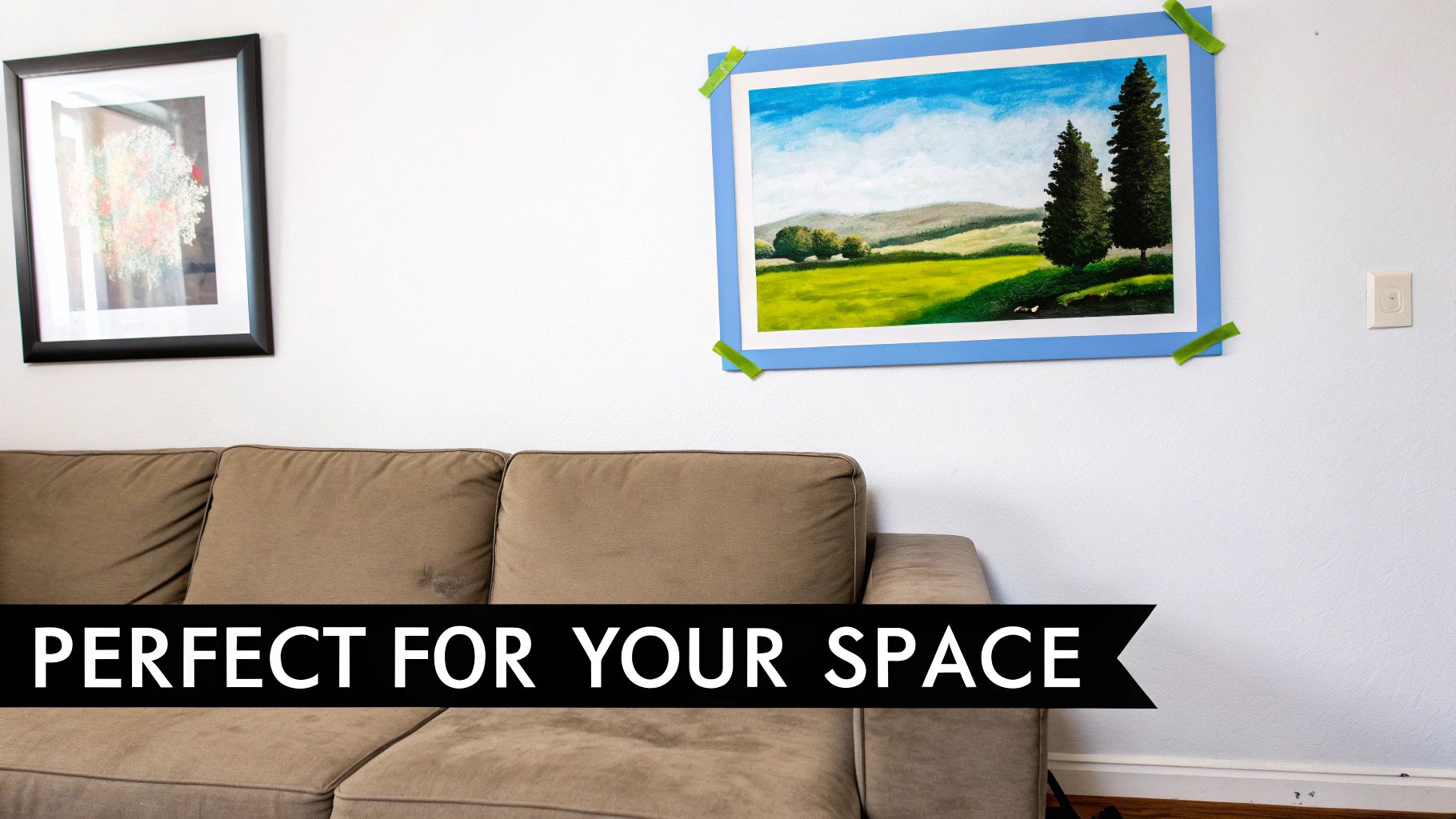 A living room featuring a brown sofa, a framed picture, and a taped landscape painting on a white wall.