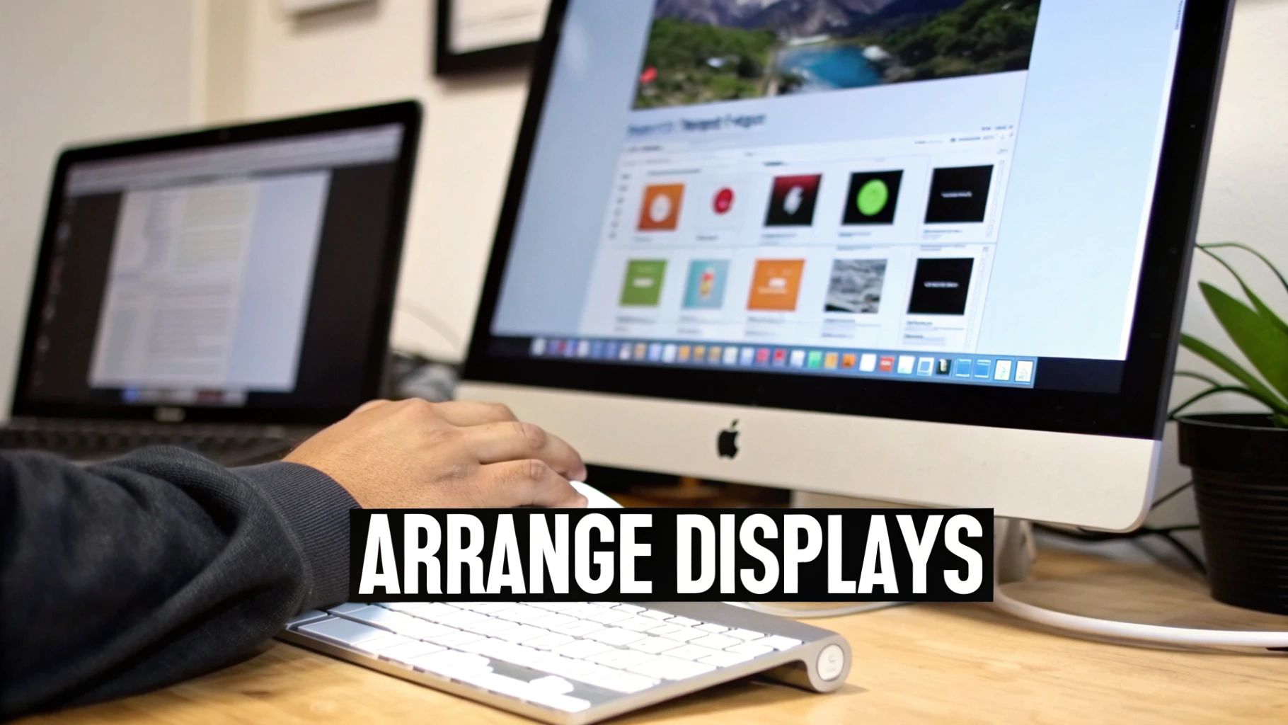 A person uses a mouse at a desk with an iMac and a MacBook, showcasing multiple displays.