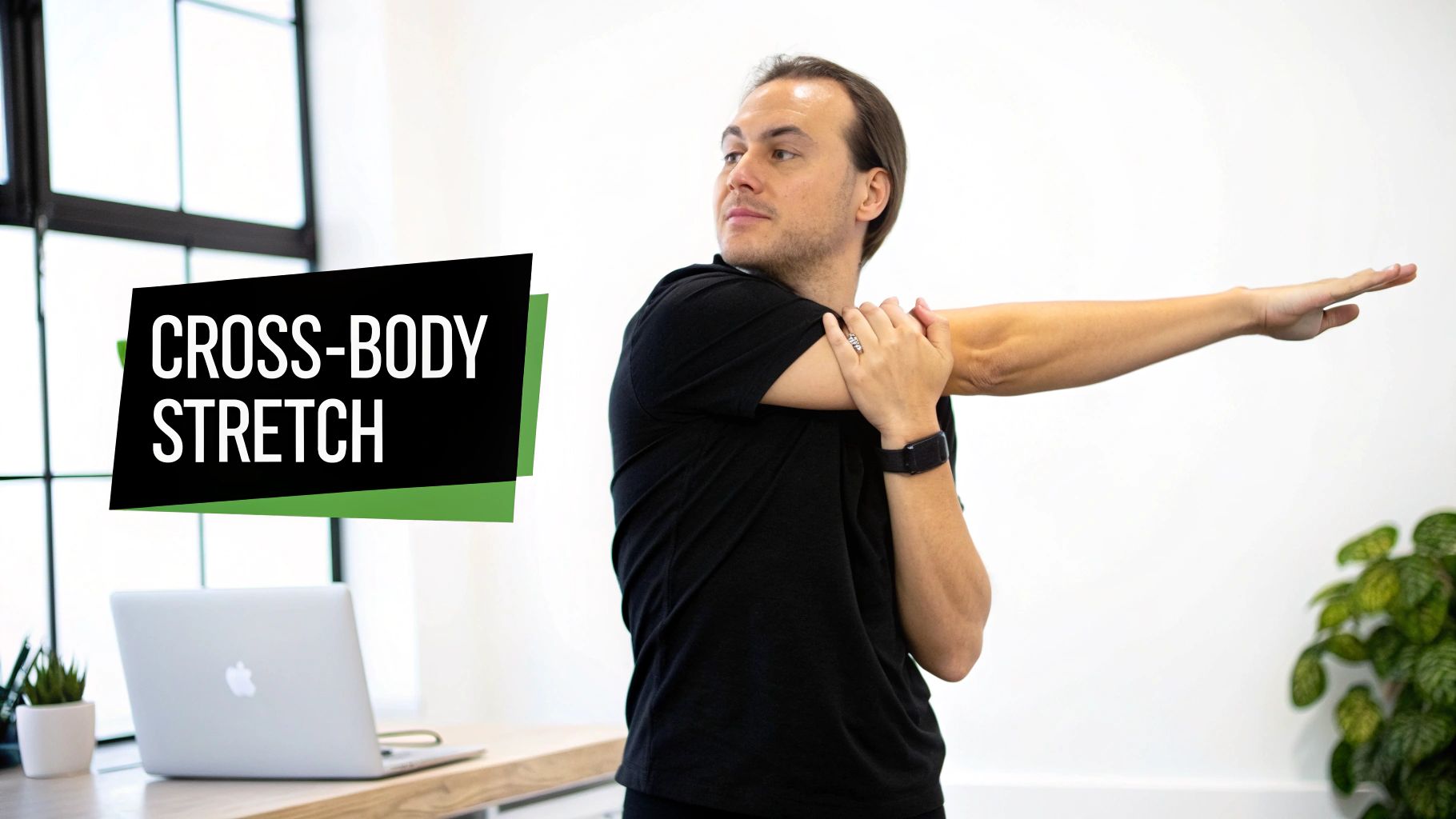 A man demonstrates a cross-body shoulder stretch, looking over his shoulder in a bright office.