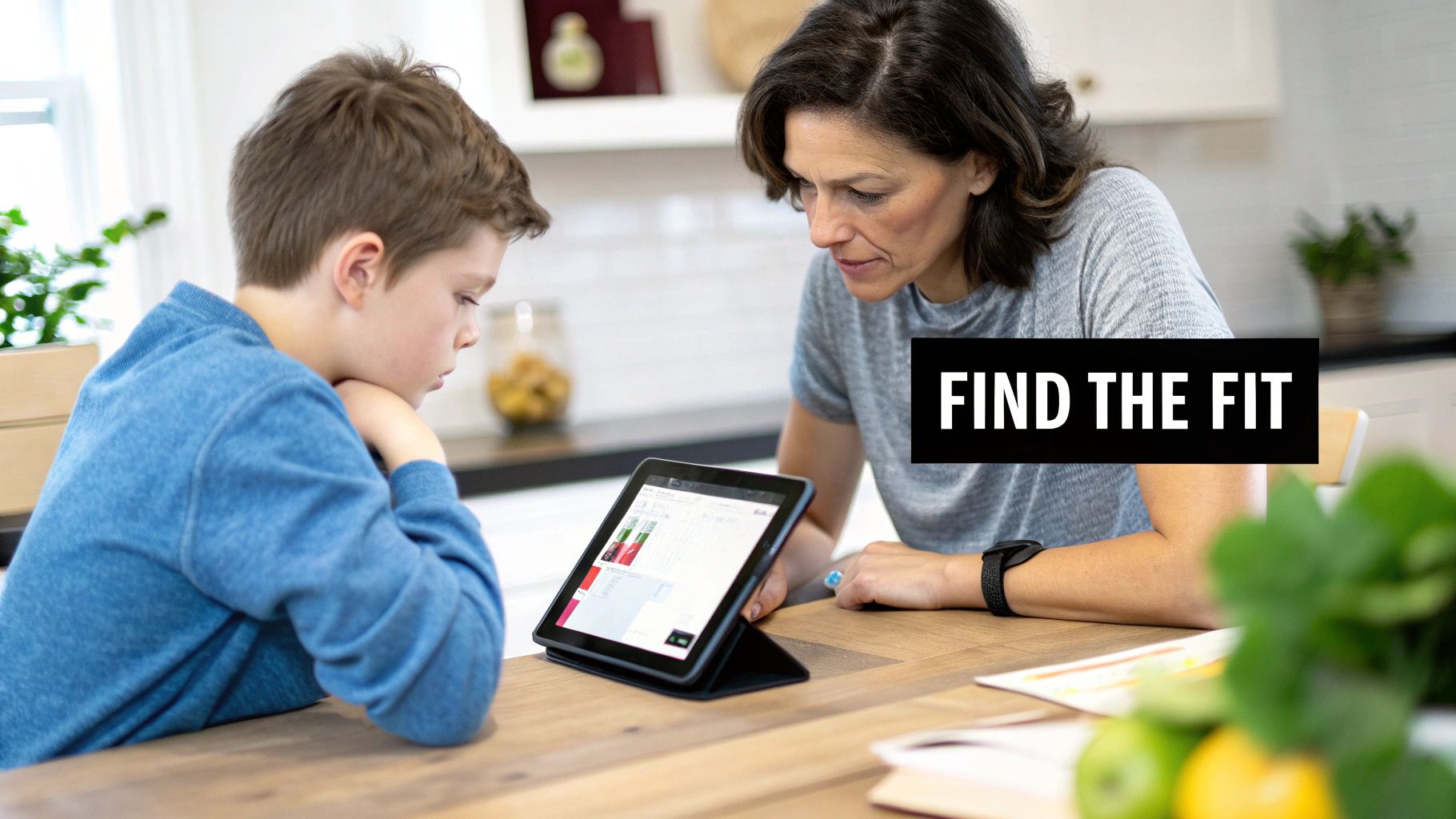 Mother and son intently looking at a tablet, engaged in online learning at home.