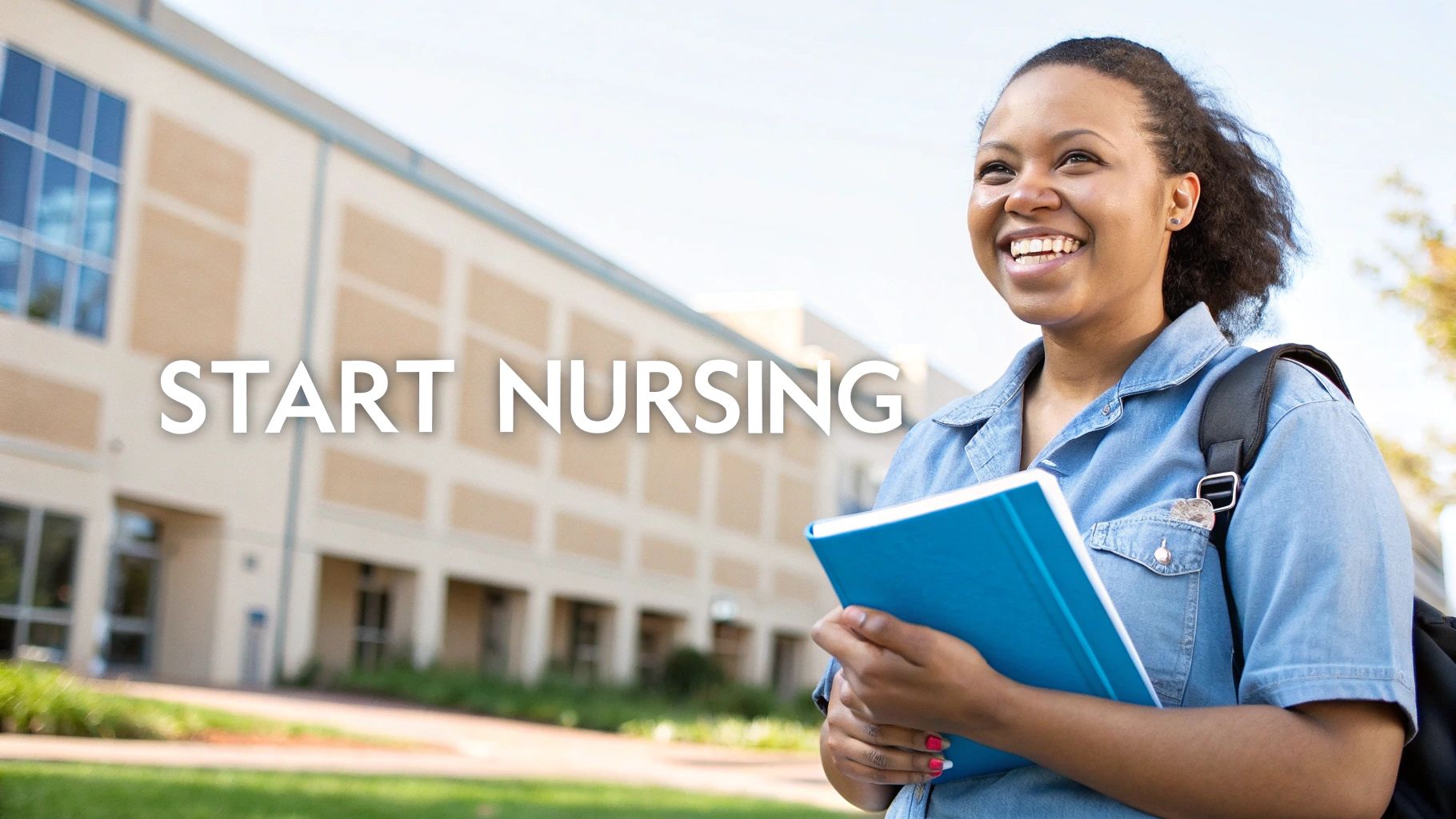 A smiling nurse in blue scrubs stands confidently in a well-lit hospital corridor.