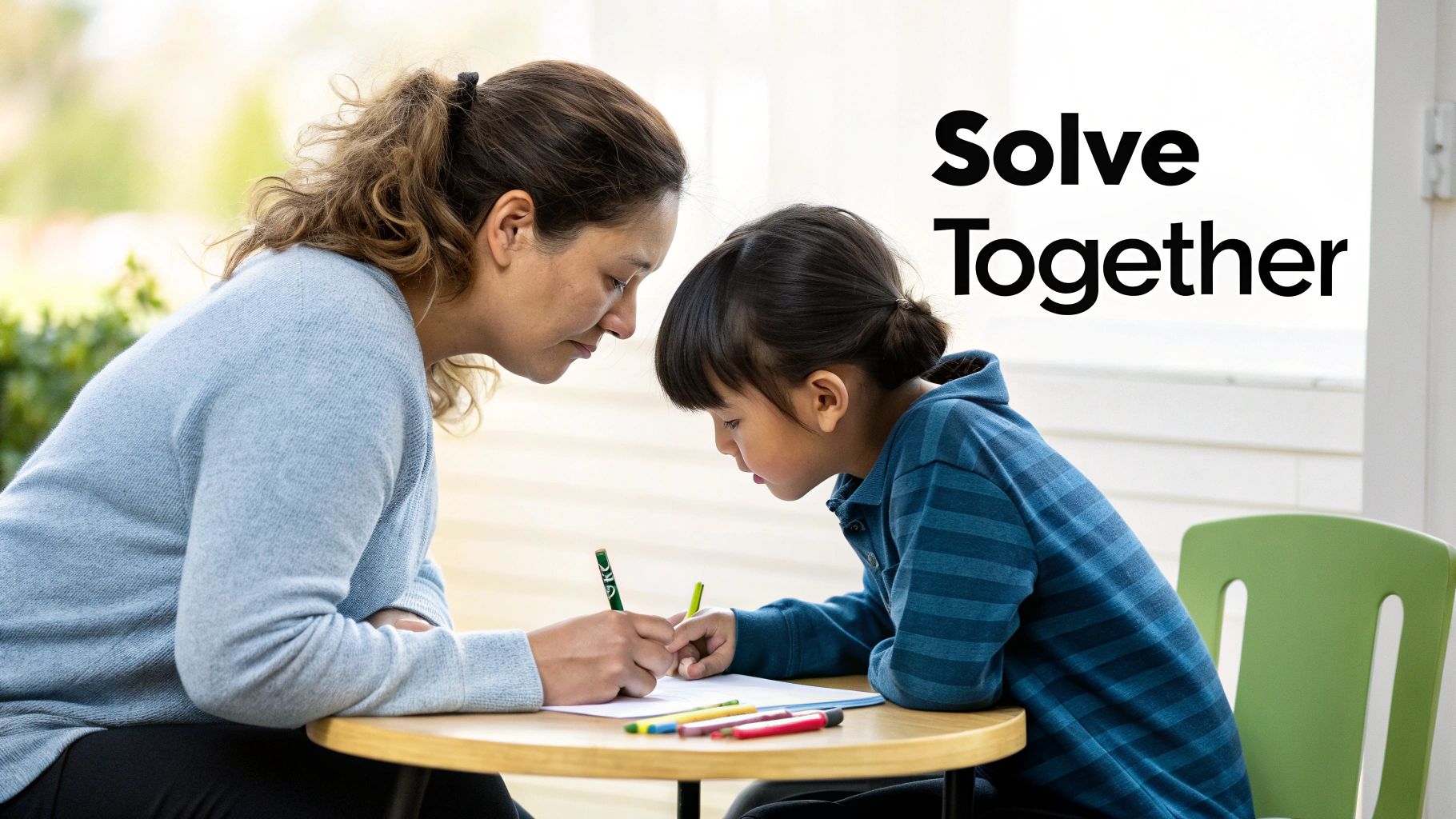 An adult and child lean over a table, writing together with colorful pens and paper.