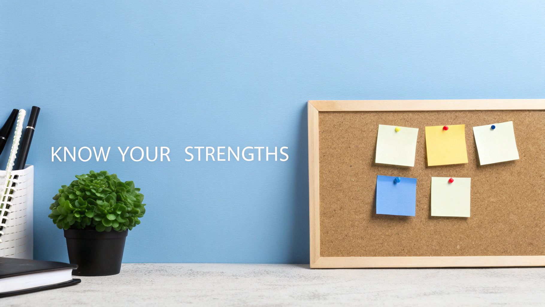 A desk with 'KNOW YOUR STRENGTHS' text, potted plant, pens, notebook, and a cork board with colorful sticky notes.