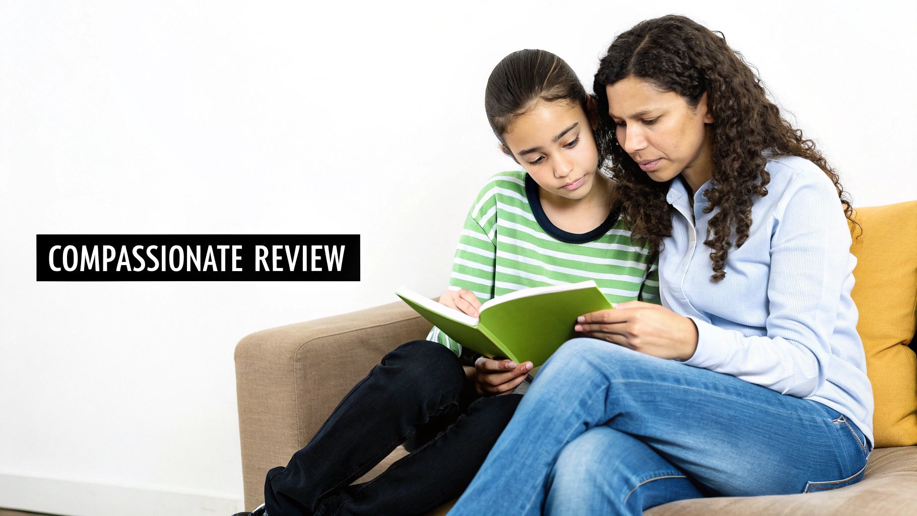 A mother and daughter sit on a couch, intently reading a green book together.