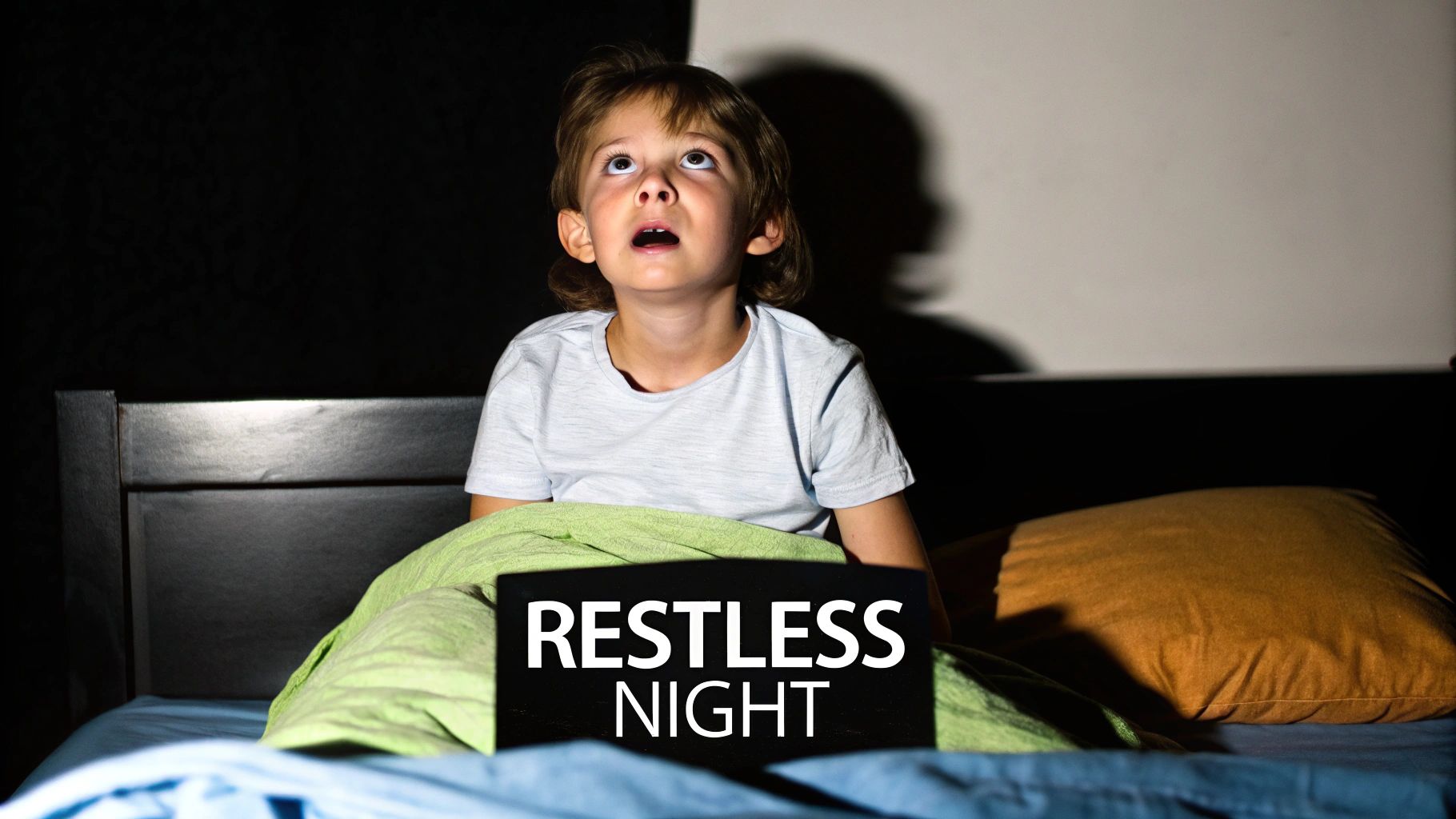 A child waking up from a nightmare, looking scared in bed, symbolising sleep disturbances due to bullying.