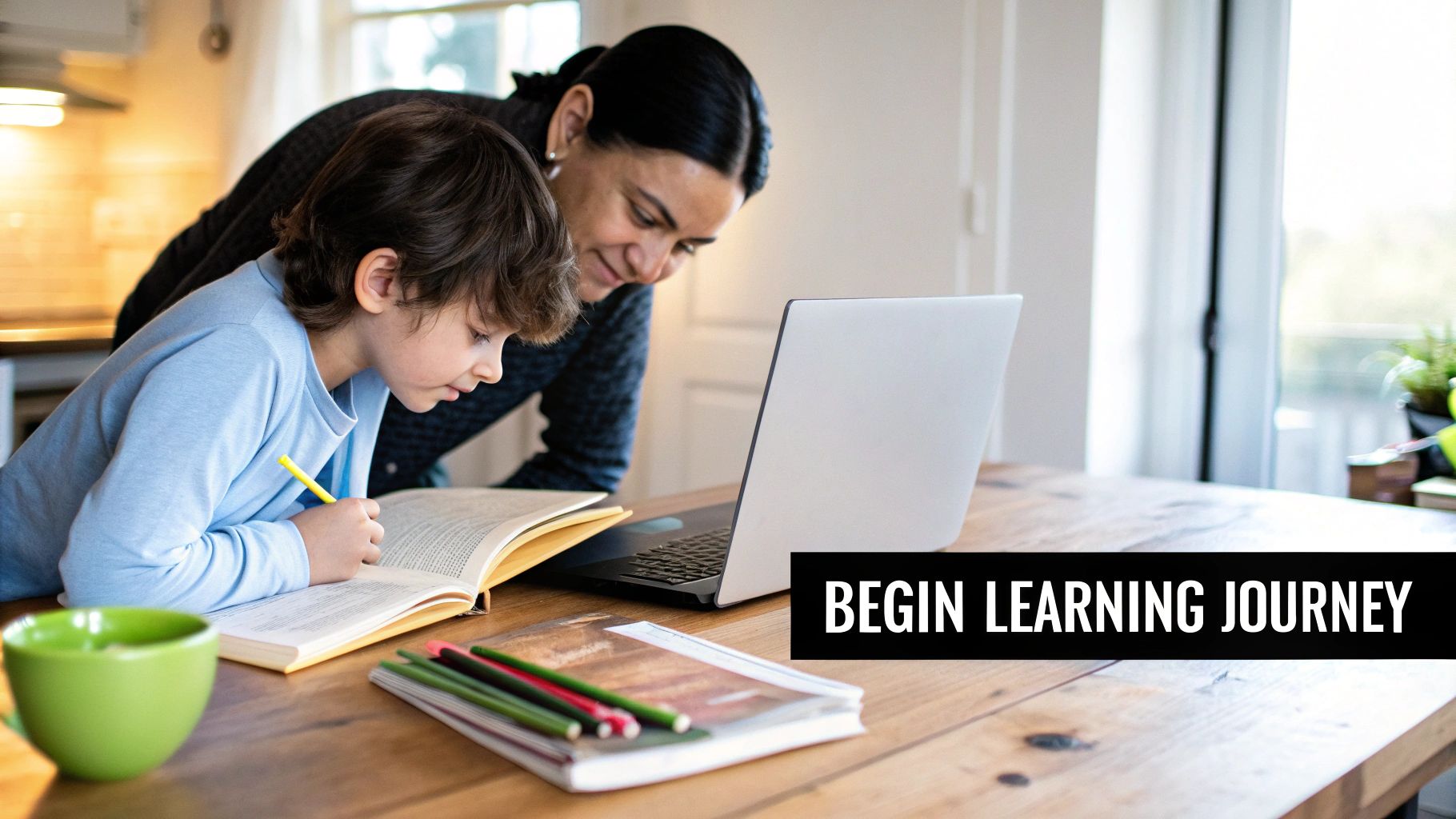 A mother and son learning together at a wooden table, child writes in a book.
