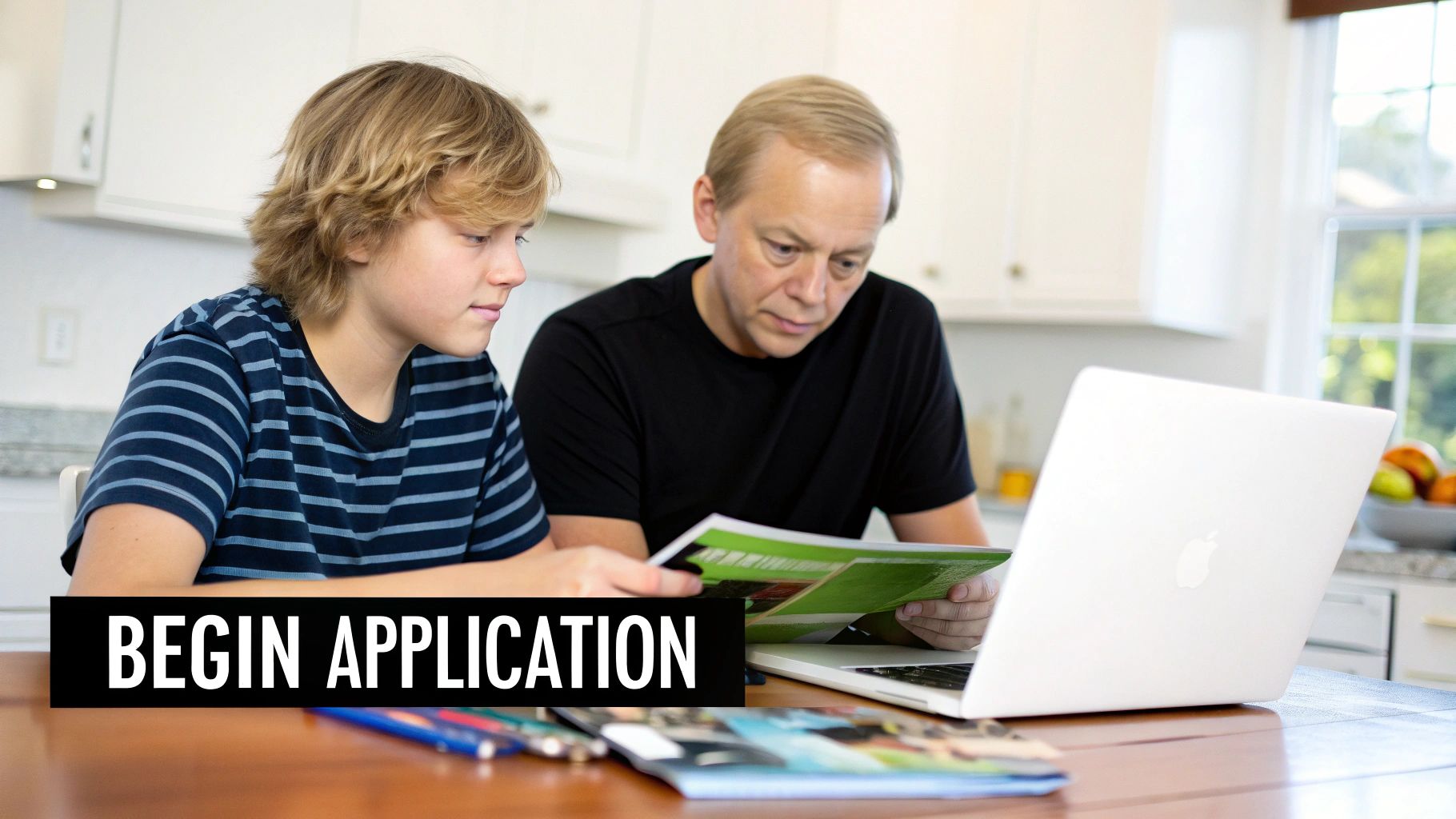 A father and son are reviewing application documents and using a laptop at home.