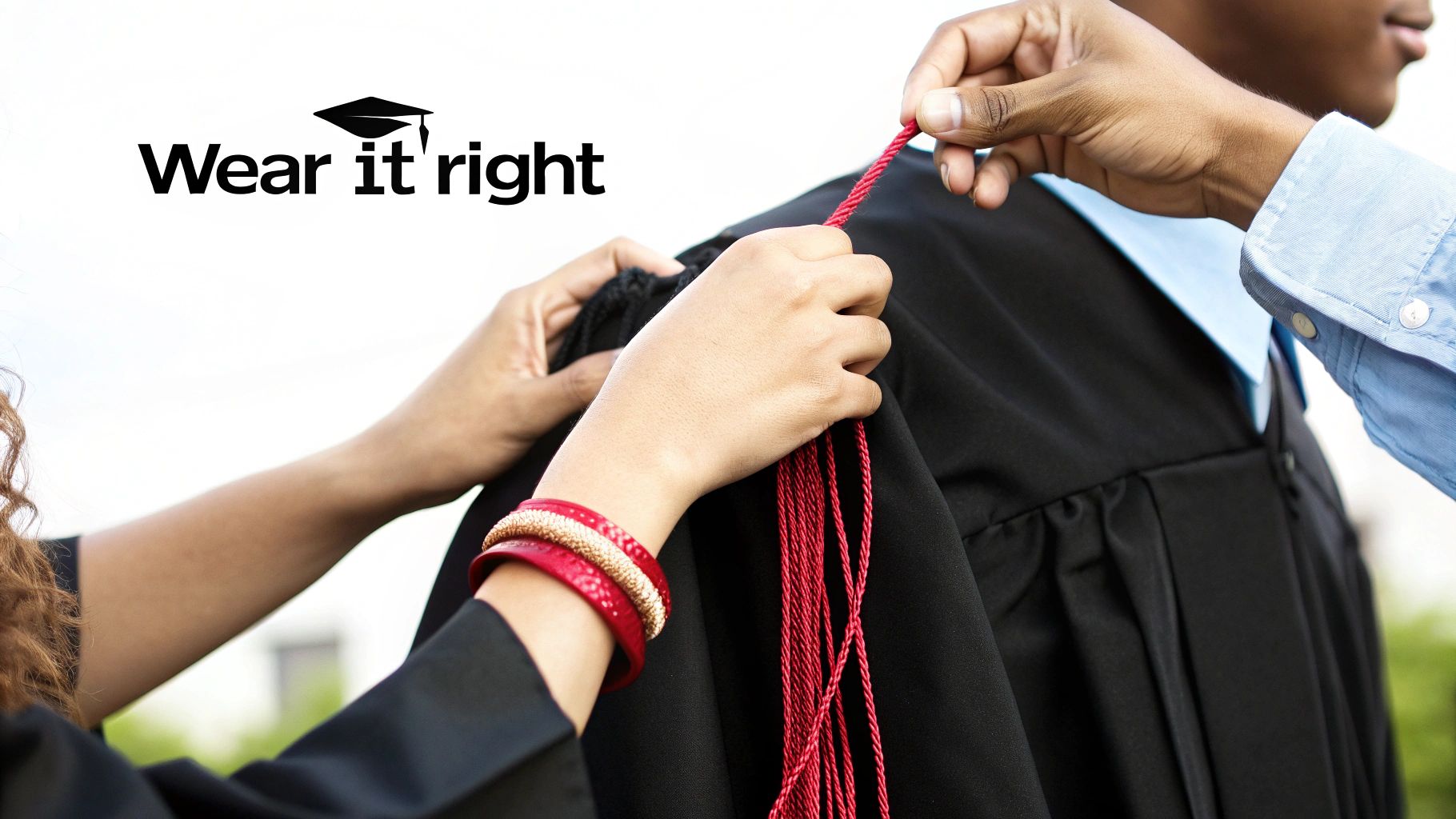 Hands arranging bright red honor cords on a black graduation gown.