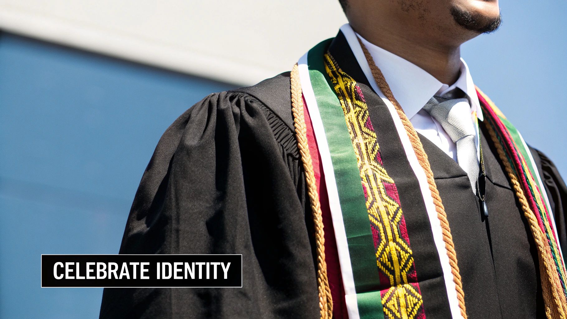 Close-up of a graduate wearing a black gown, colorful honor cords, and stole. Text: CELEBRATE IDENTITY.
