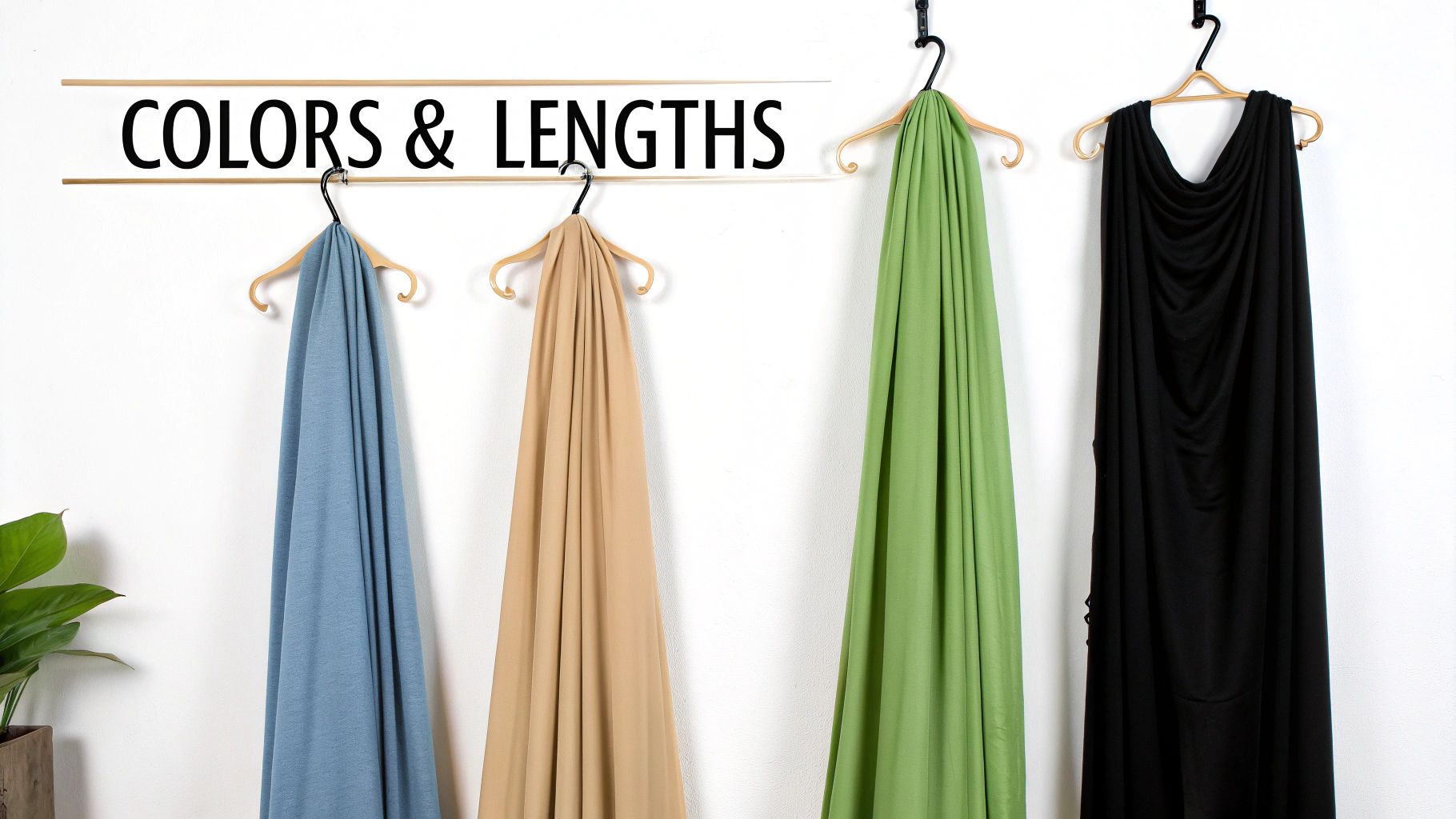 Four different colored fabrics: blue, beige, green, and black, draped on hangers.
