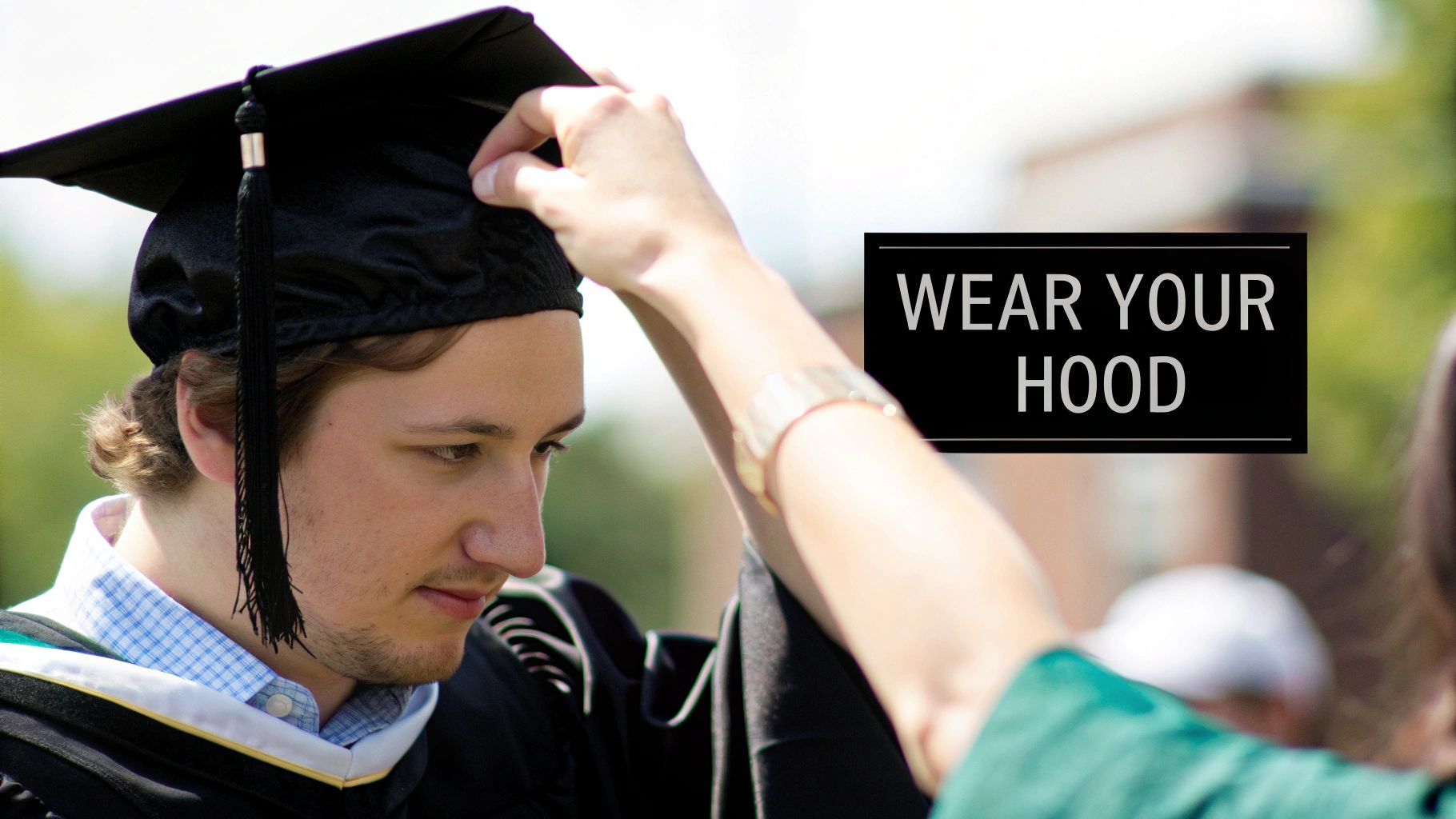 A graduate wearing an academic hood correctly over their graduation gown.