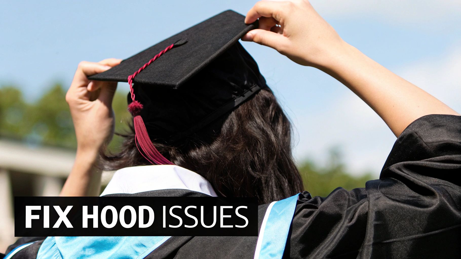 A graduate from behind adjusts their black mortarboard cap and gown under a blue sky.
