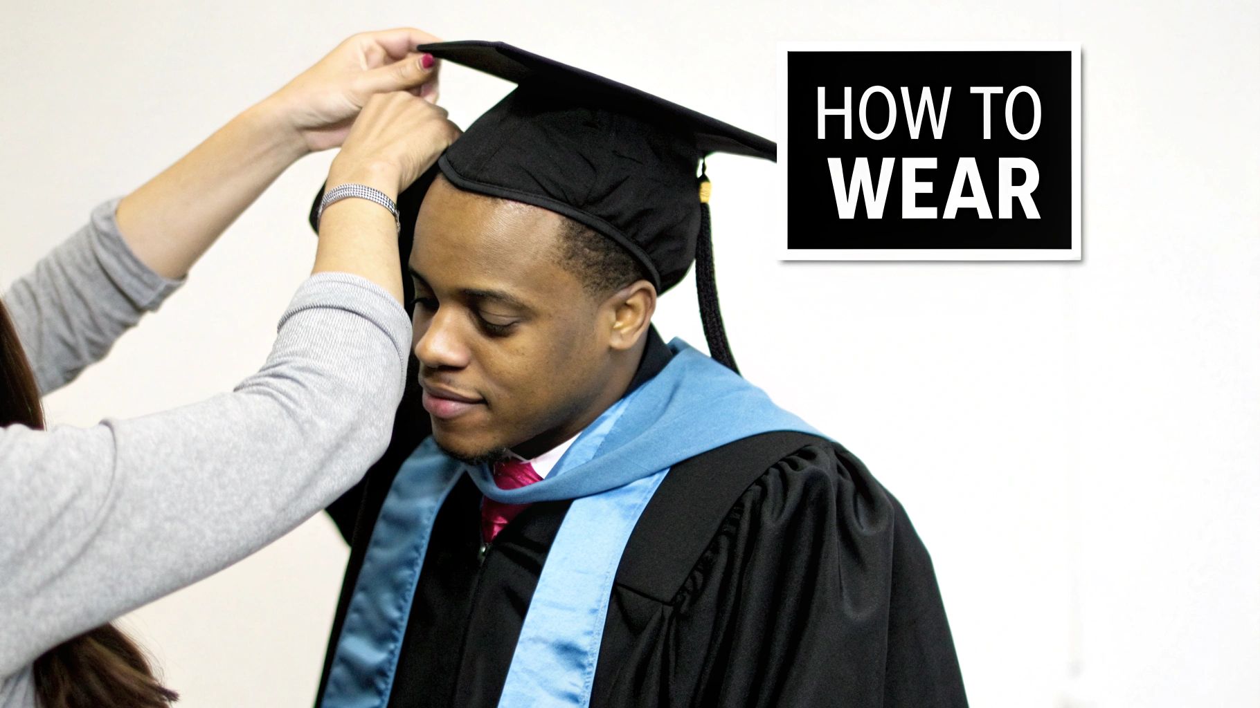 A person adjusts a graduation cap on a young man wearing a black gown and blue hood, with 'HOW TO WEAR' text.