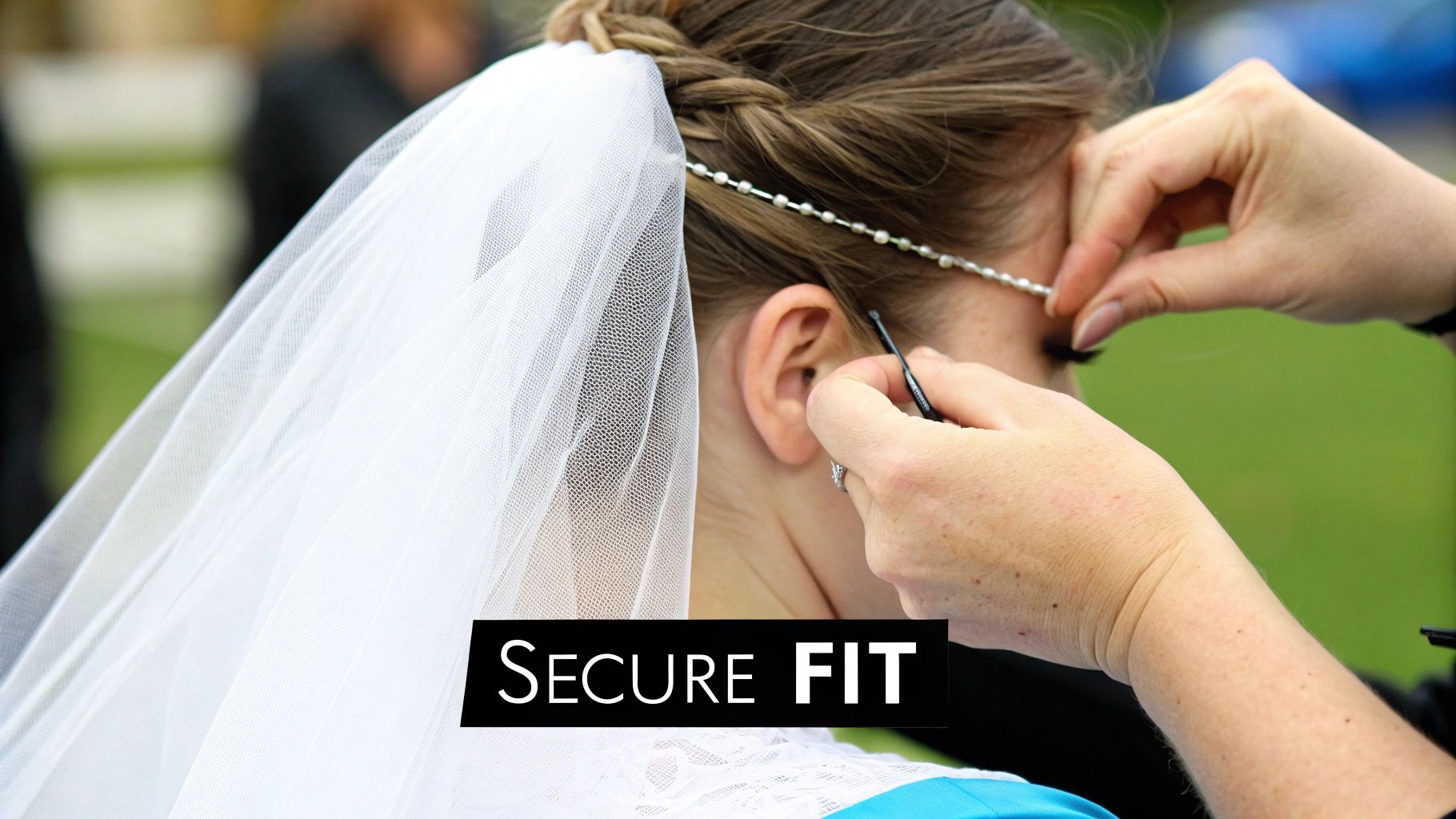 Close-up of a person's hands securing a delicate white wedding veil and pearl headpiece on a bride's hair.