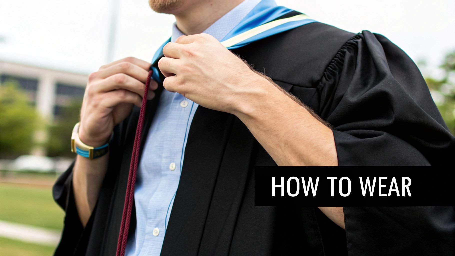 A graduate adjusts their blue and yellow academic hood and maroon cord over a black gown, with text 'HOW TO WEAR'.