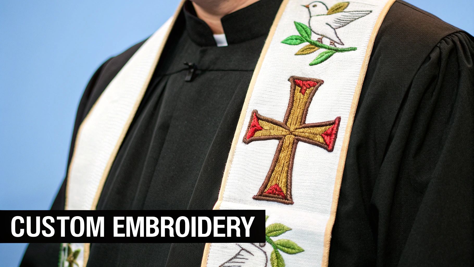 Close-up of a person in a black robe and a white stole with custom embroidered cross and dove.