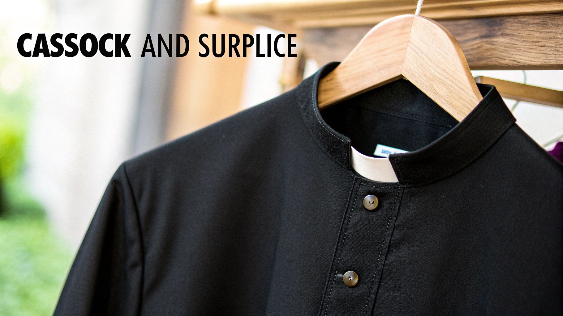 Black clerical cassock with a white collar on a wooden hanger, 'CASSOCK AND SURPLICE' text.