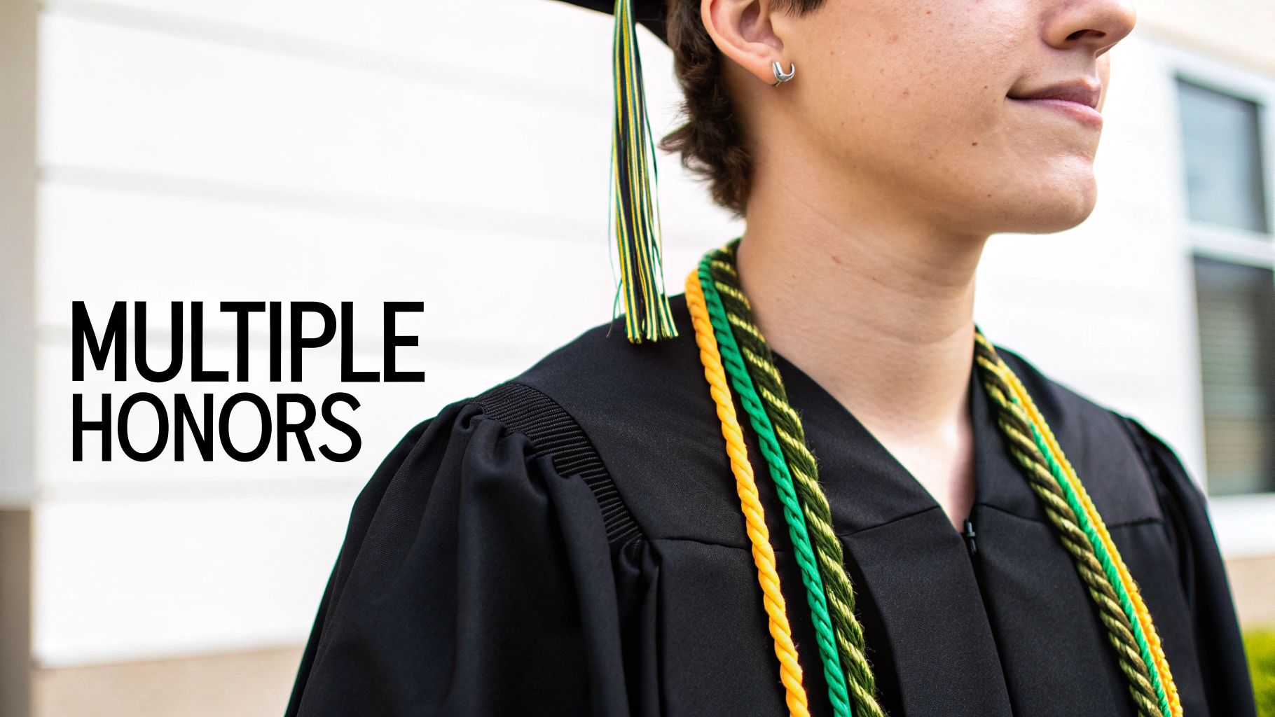 A graduate wears a black cap and gown, adorned with multiple colorful honor cords.