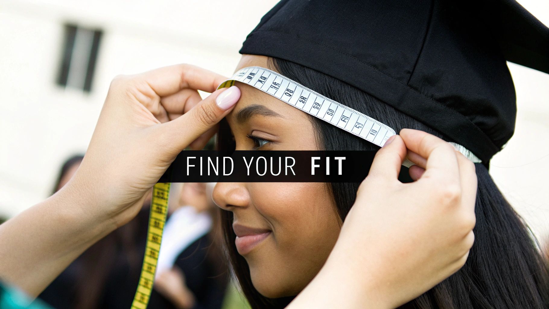 A person uses a measuring tape to size the head of a smiling graduate wearing a black cap.