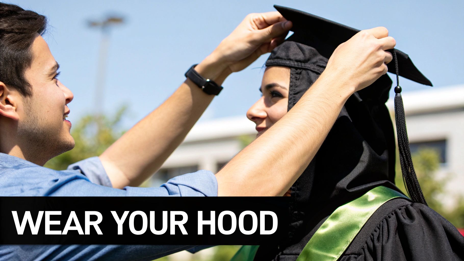 A graduate adjusting their graduation hood.