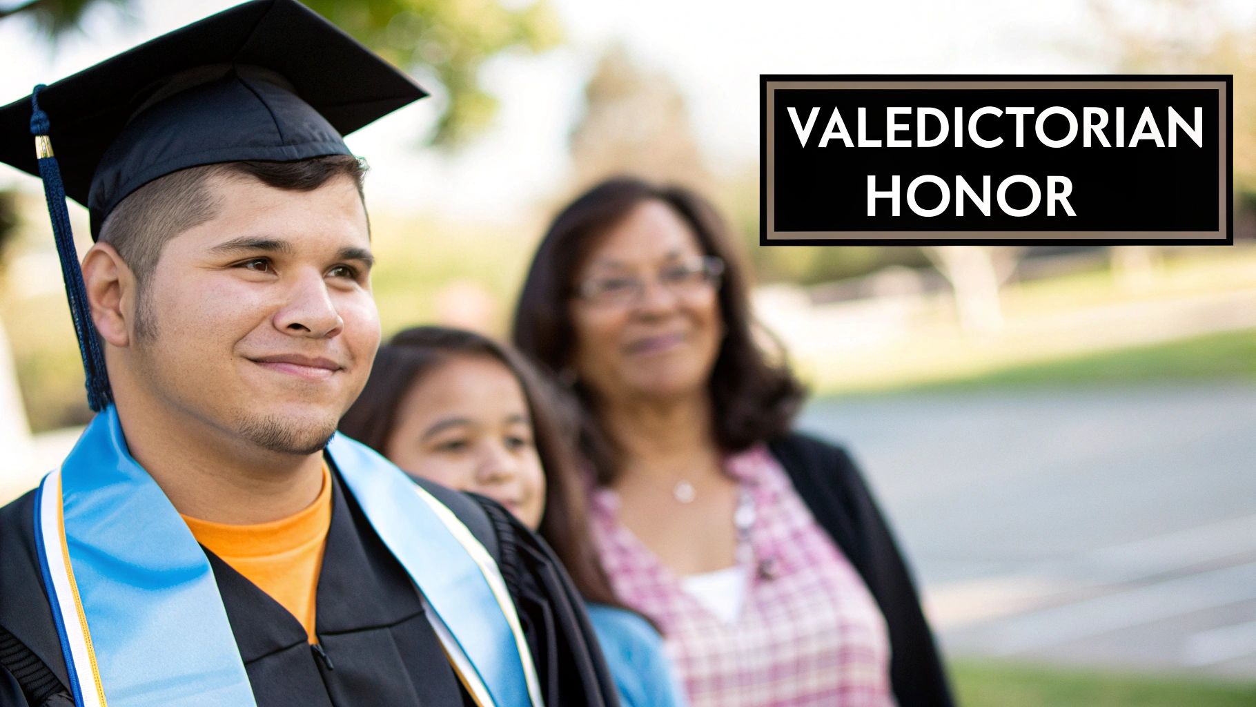 Smiling male graduate wearing a cap, gown, and blue stole with 'Valedictorian Honor' text.