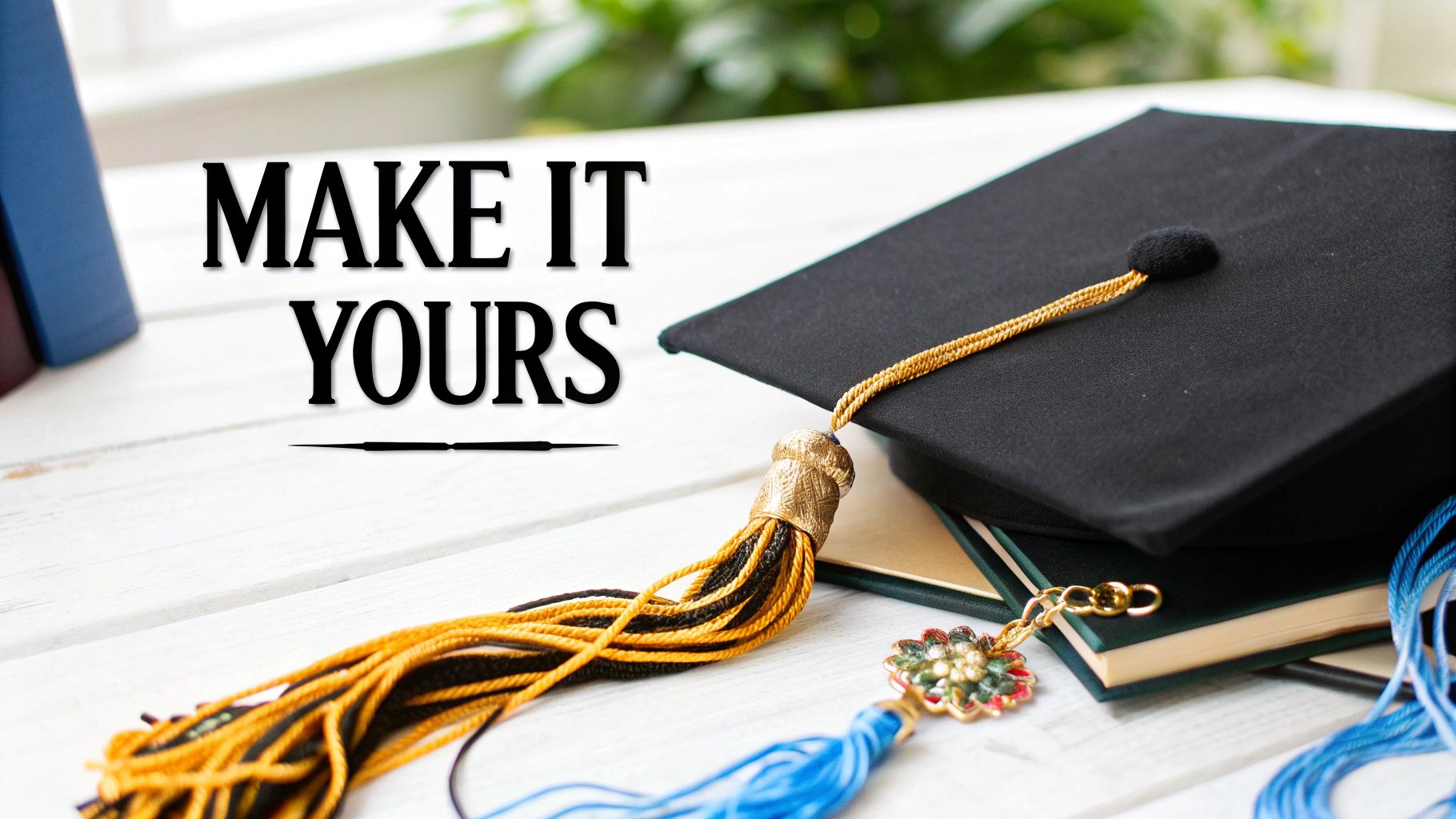 A black graduation cap with a gold tassel rests on books, near a blue tassel and charm. Text: MAKE IT YOURS.