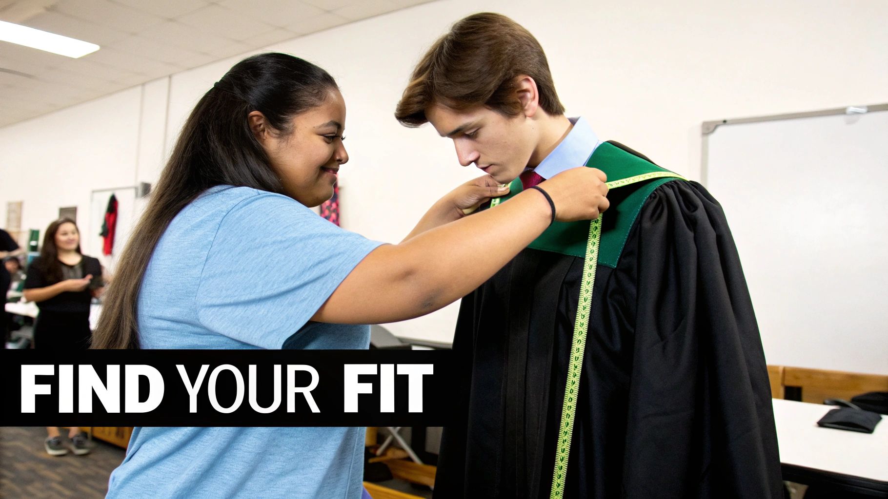 A smiling woman measures a young man in a black graduation gown with a green stole, fitting him.