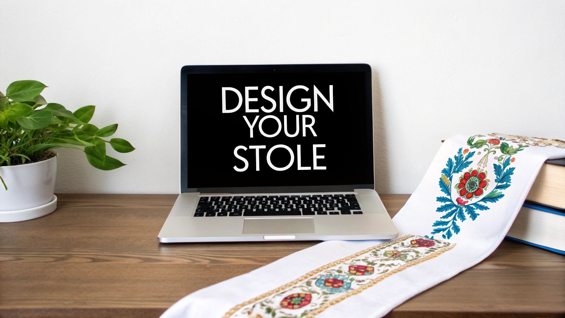 A laptop displaying 'DESIGN YOUR STOLE' sits on a wooden desk next to a potted plant and an embroidered stole over books.