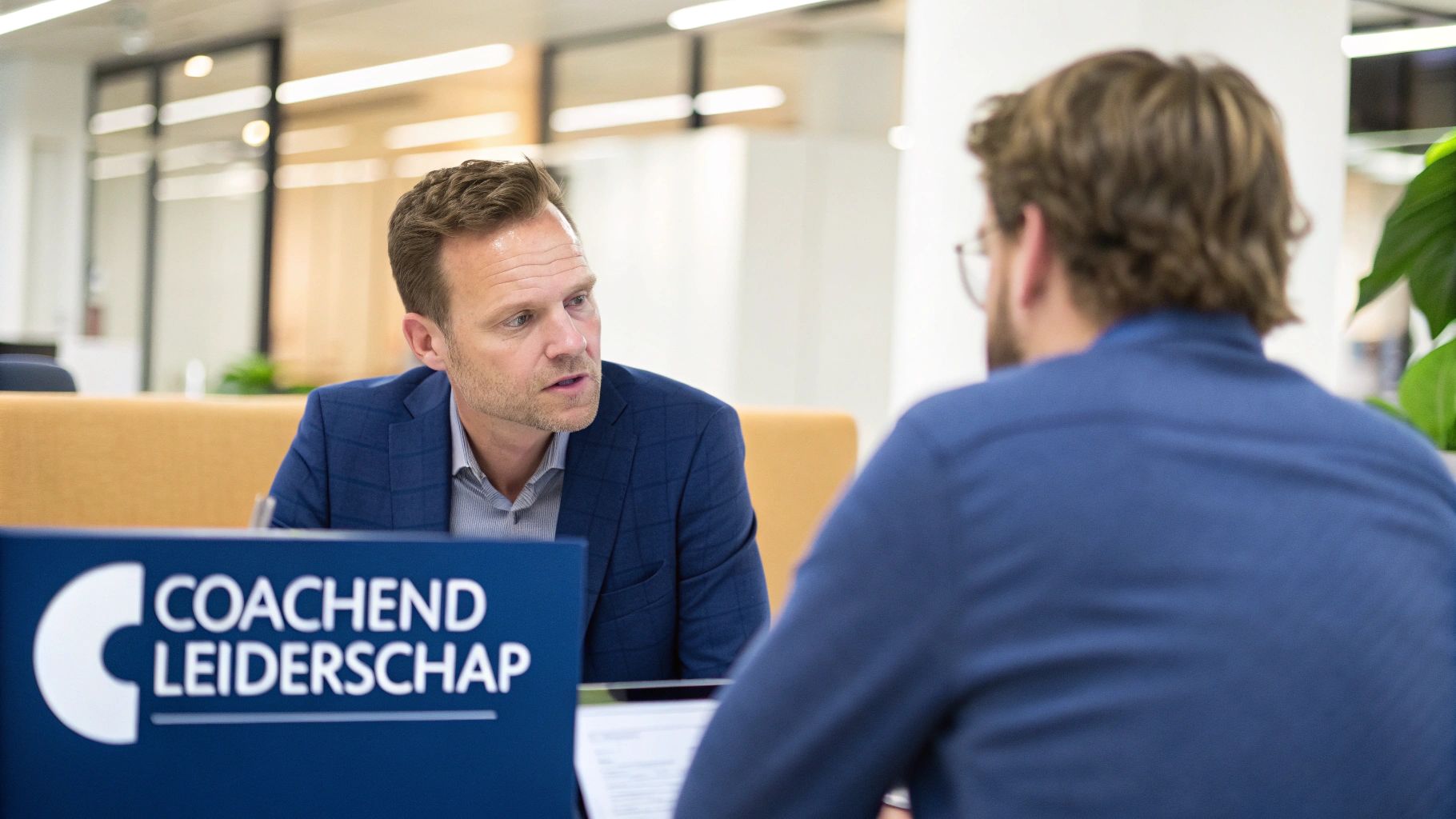 Een leider die een teamlid coacht in een moderne kantooromgeving